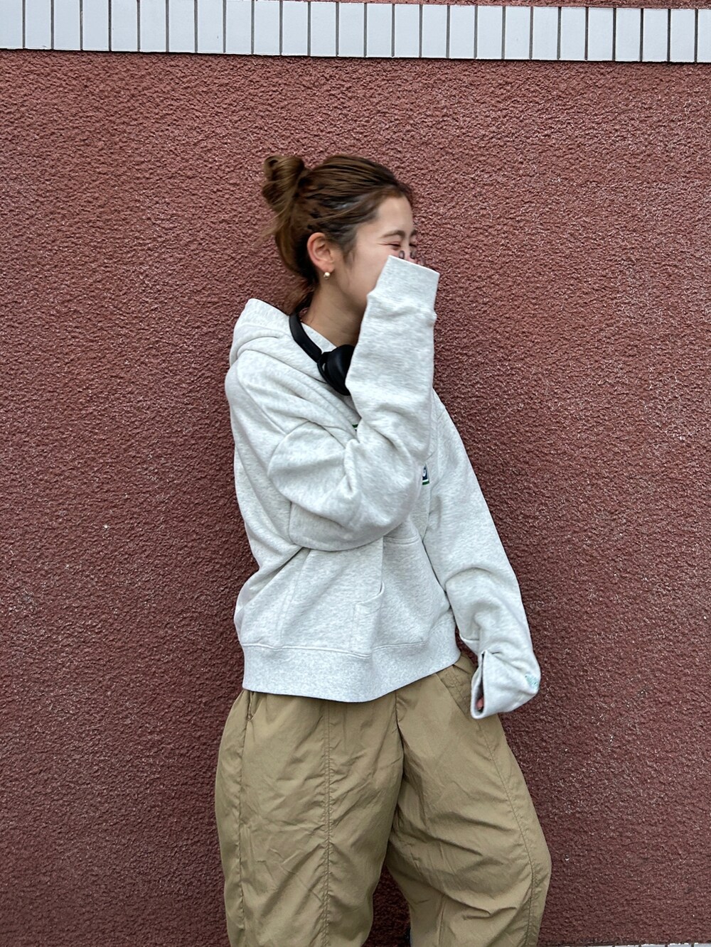 グレー系のパーカー、ベージュ系のその他パンツを着用したレディースの冬コーディネートの5枚目の写真