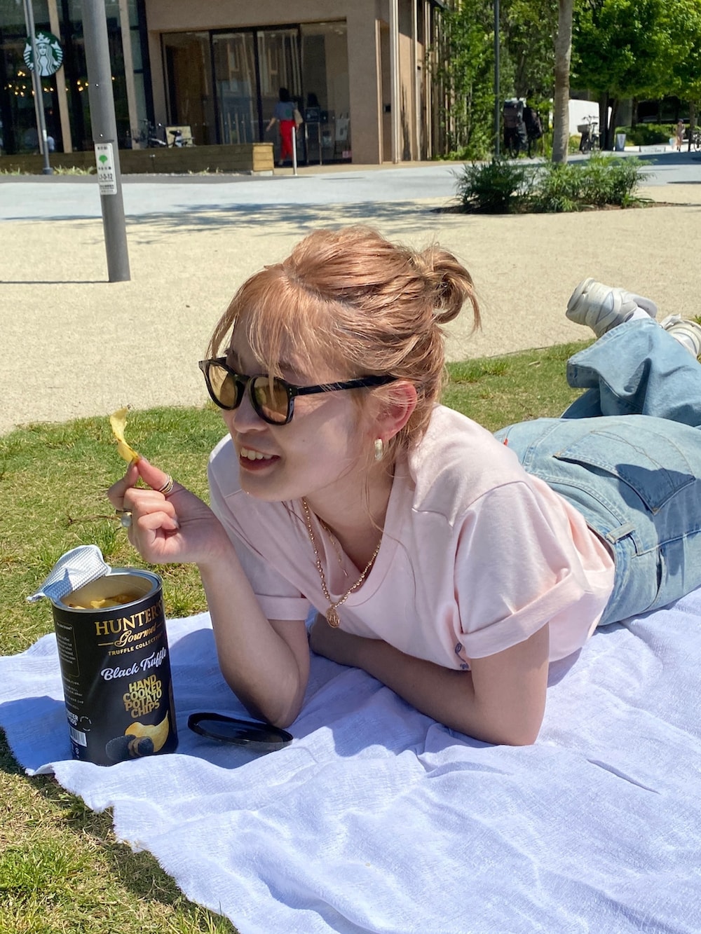 ピンク系のTシャツ/カットソー、ブルー系のデニムパンツ、ブルー系のショルダーバッグを着用したレディースの夏コーディネートの2枚目の写真