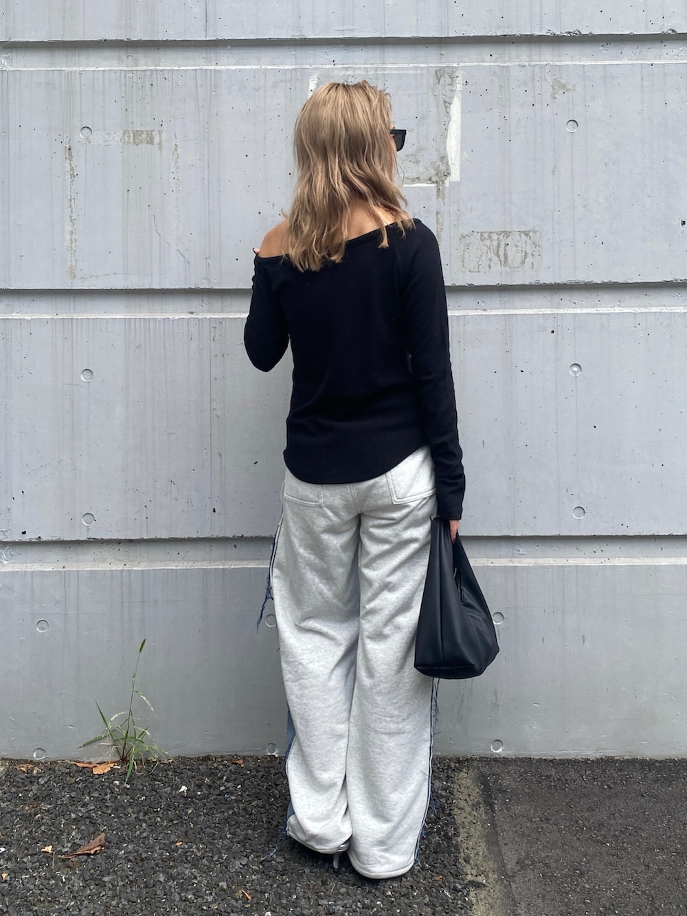 ブラック系のTシャツ/カットソー、ブルー系のデニムパンツ、ブラック系のハンドバッグを着用したレディースの秋コーディネートの3枚目の写真
