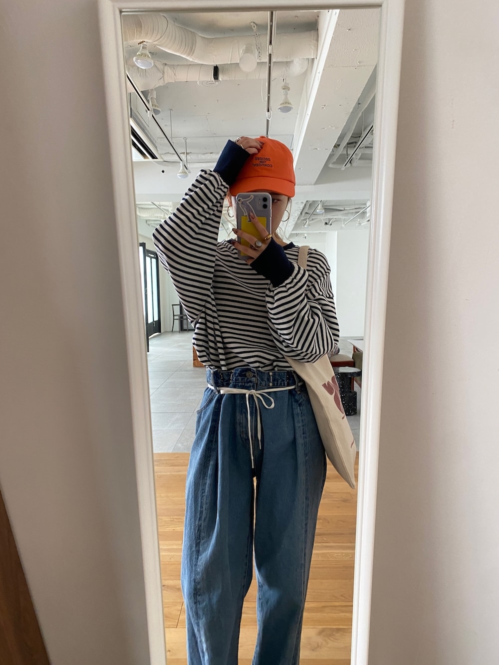 ブルー系のTシャツ/カットソー、ブルー系のデニムパンツ、レッド系のトートバッグを着用したレディースの冬コーディネートの4枚目の写真