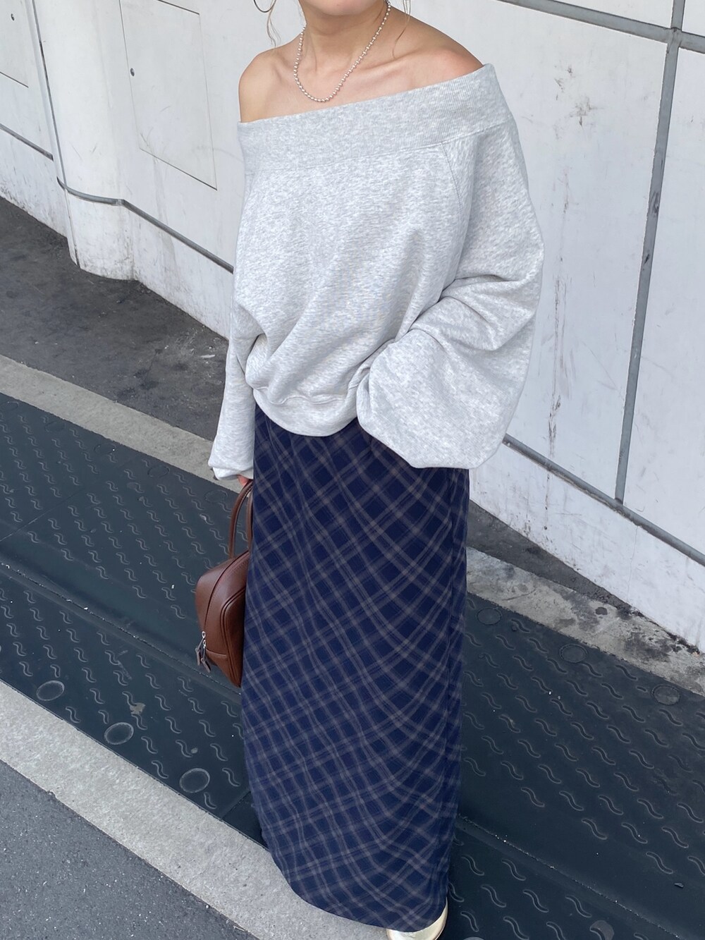 グレー系のスウェット、ブルー系のスカート、ゴールド系のバレエシューズを着用したレディースの夏コーディネートの7枚目の写真