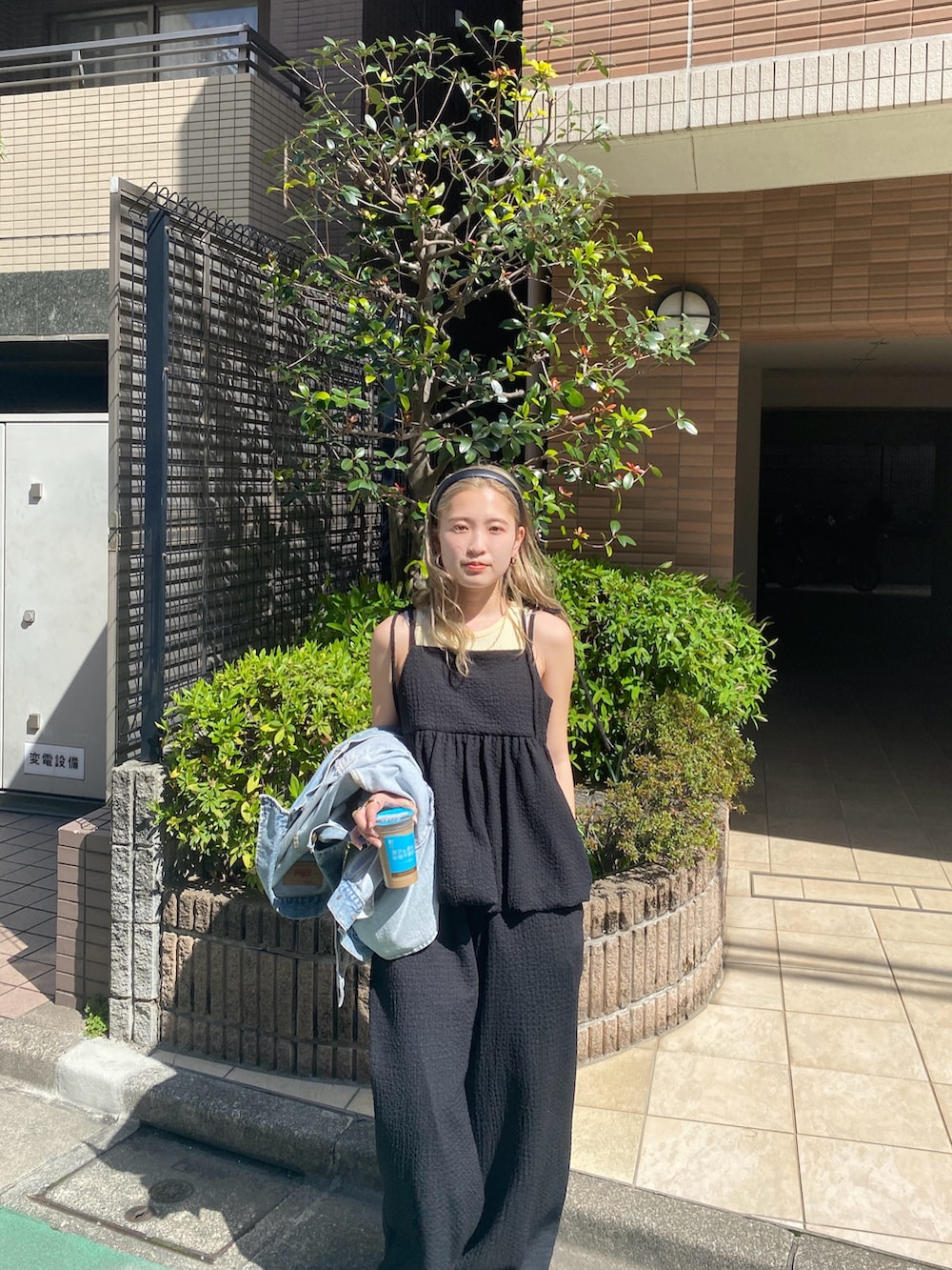 ブラック系のワンピース、イエロー系のタンクトップを着用したレディースの夏コーディネートの2枚目の写真