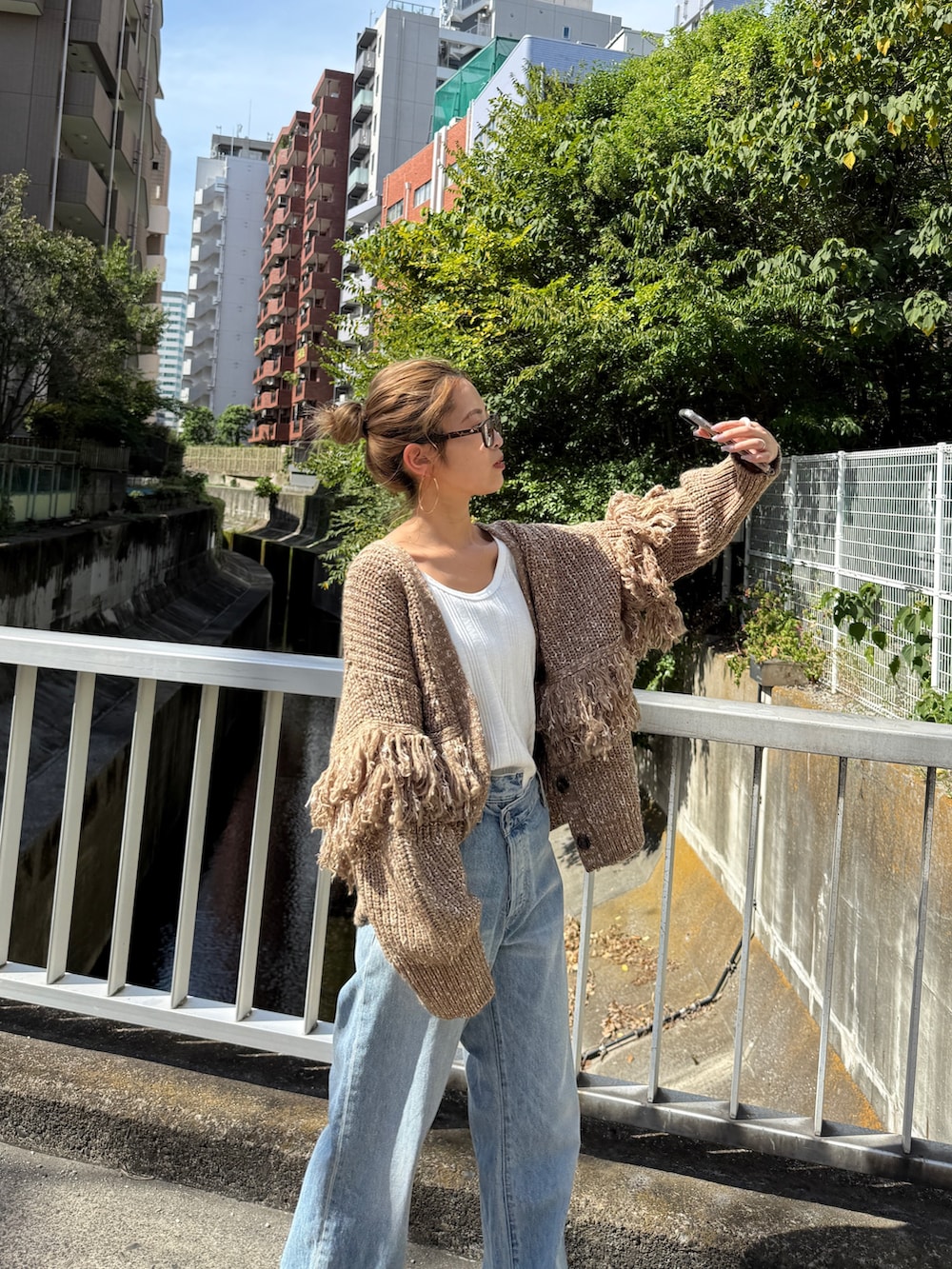 ブラウン系のカーディガン/ボレロ、ブルー系のデニムパンツ、ブラウン系のブーツを着用したレディースの冬コーディネートの5枚目の写真