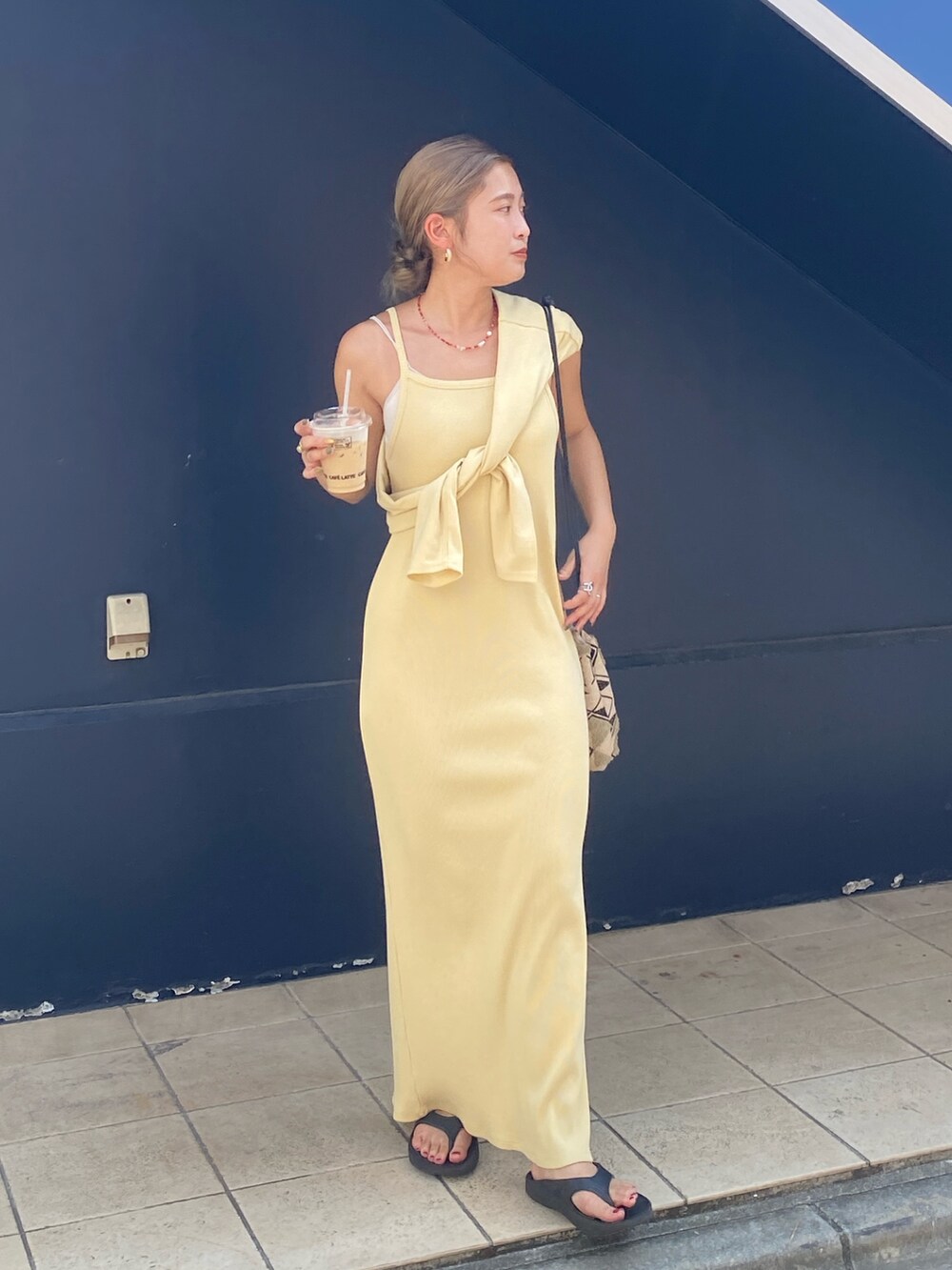 イエロー系のワンピース、レッド系のネックレスを着用したレディースの夏コーディネートの3枚目の写真