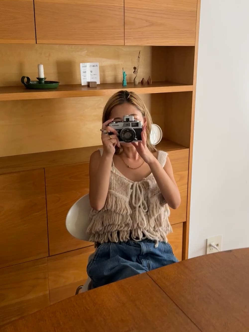 ホワイト系のニット/セーター、ブルー系のデニムパンツ、ブラウン系のスニーカーを着用したレディースの秋コーディネートの2枚目の写真