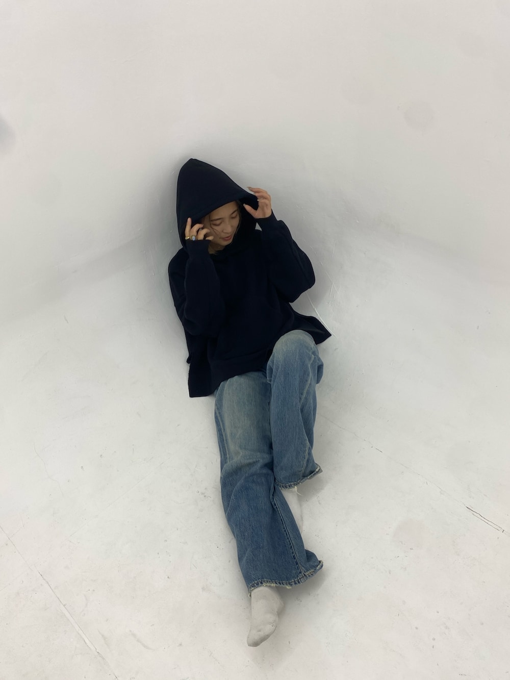 ブラック系のパーカー、ブルー系のデニムパンツを着用したレディースの秋コーディネートの2枚目の写真