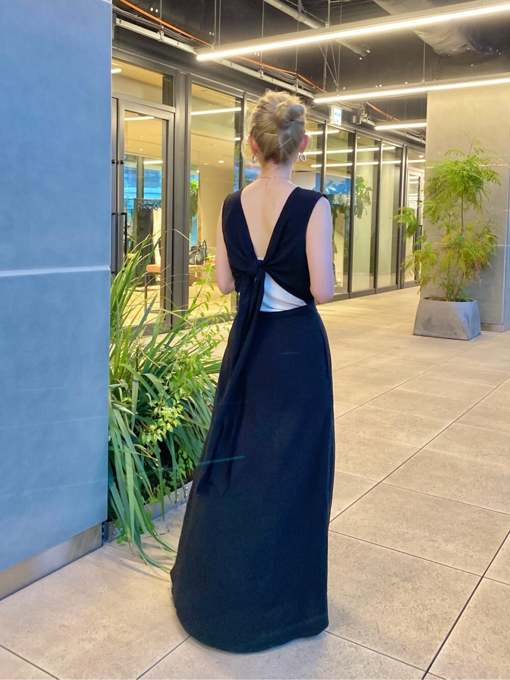 グリーン系のハンドバッグ、ブラック系のワンピースを着用したレディースの春コーディネートの3枚目の写真