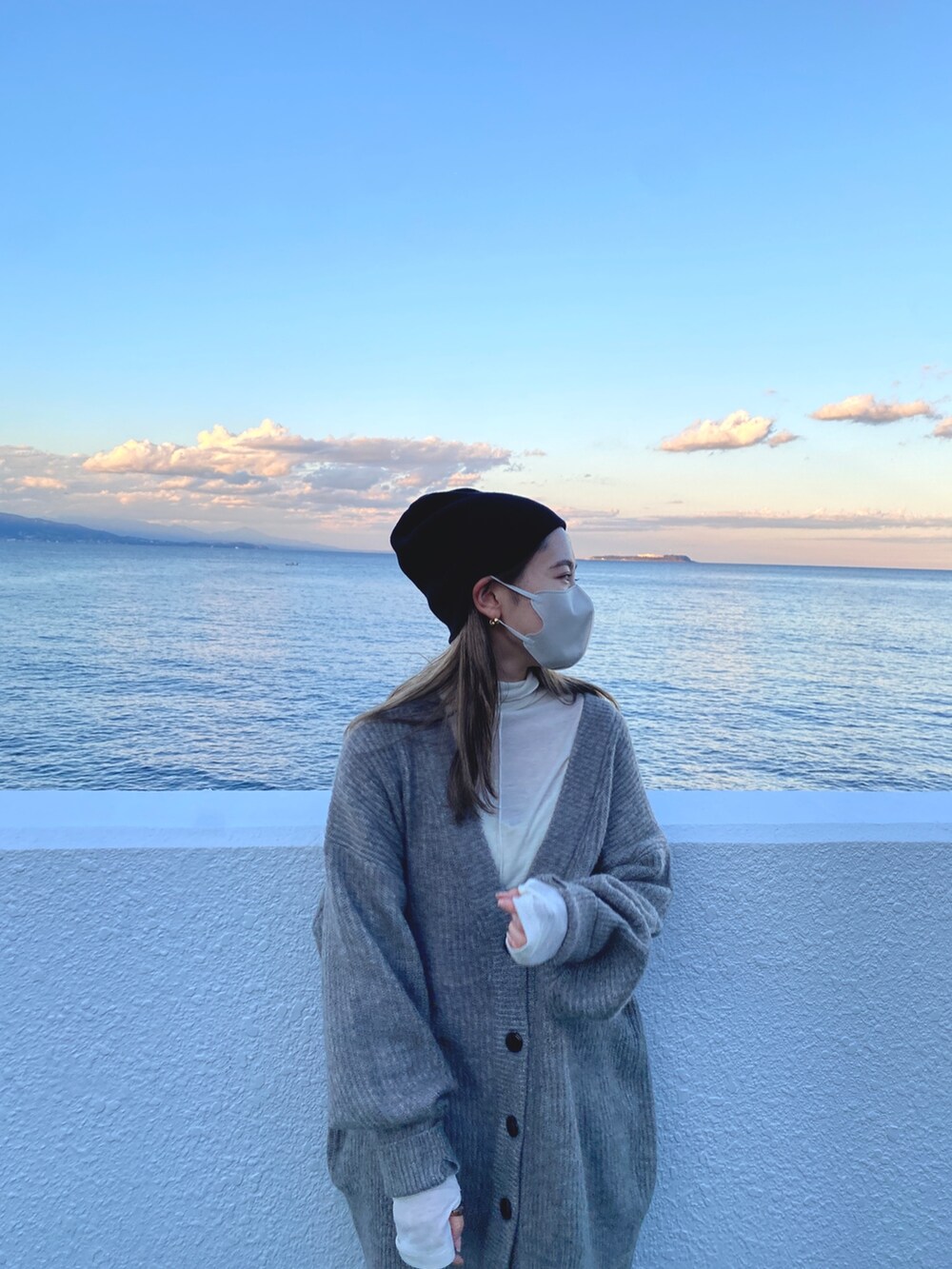 グレー系のカーディガン/ボレロ、ホワイト系のTシャツ/カットソー、ブラック系のニットキャップ/ビーニーを着用したレディースの冬コーディネートの4枚目の写真