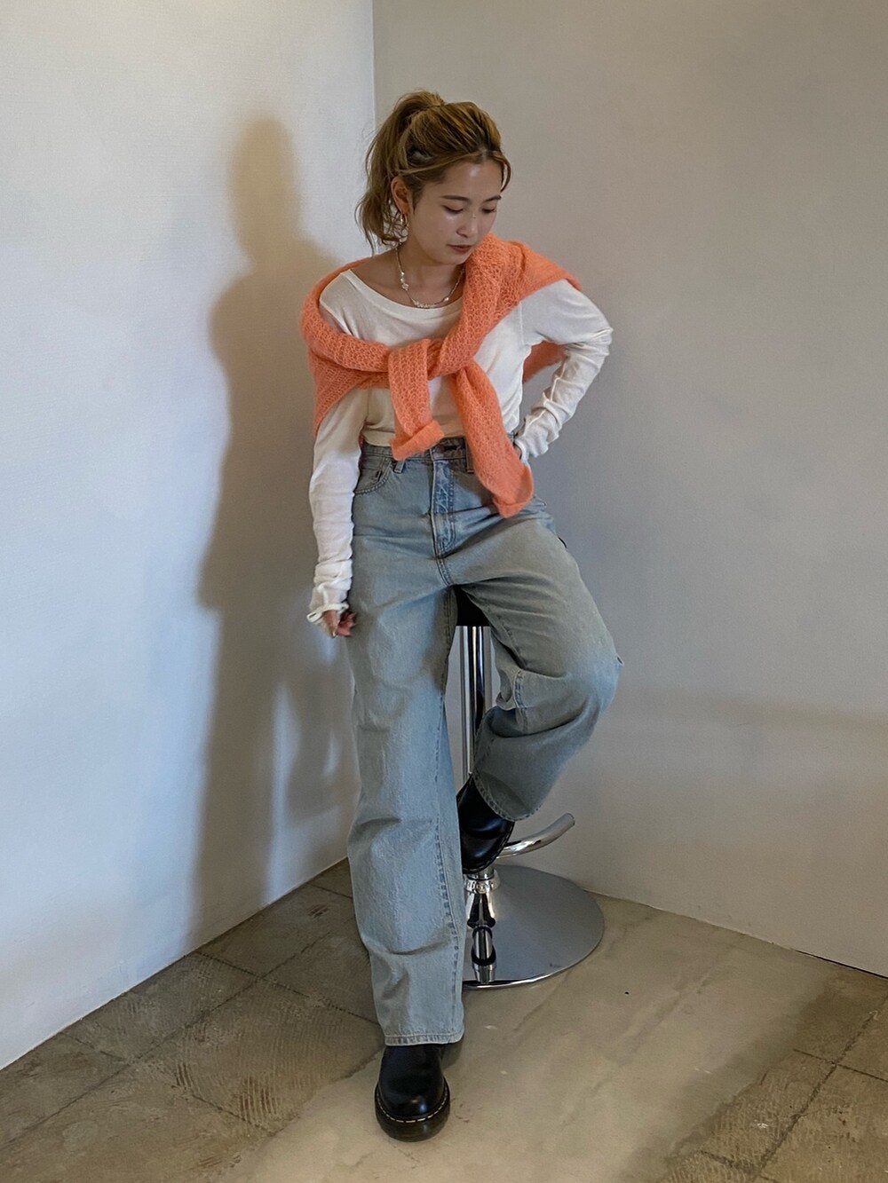 ピンク系のニット/セーター、ホワイト系のTシャツ/カットソー、ブルー系のデニムパンツを着用したレディースの秋コーディネートの3枚目の写真