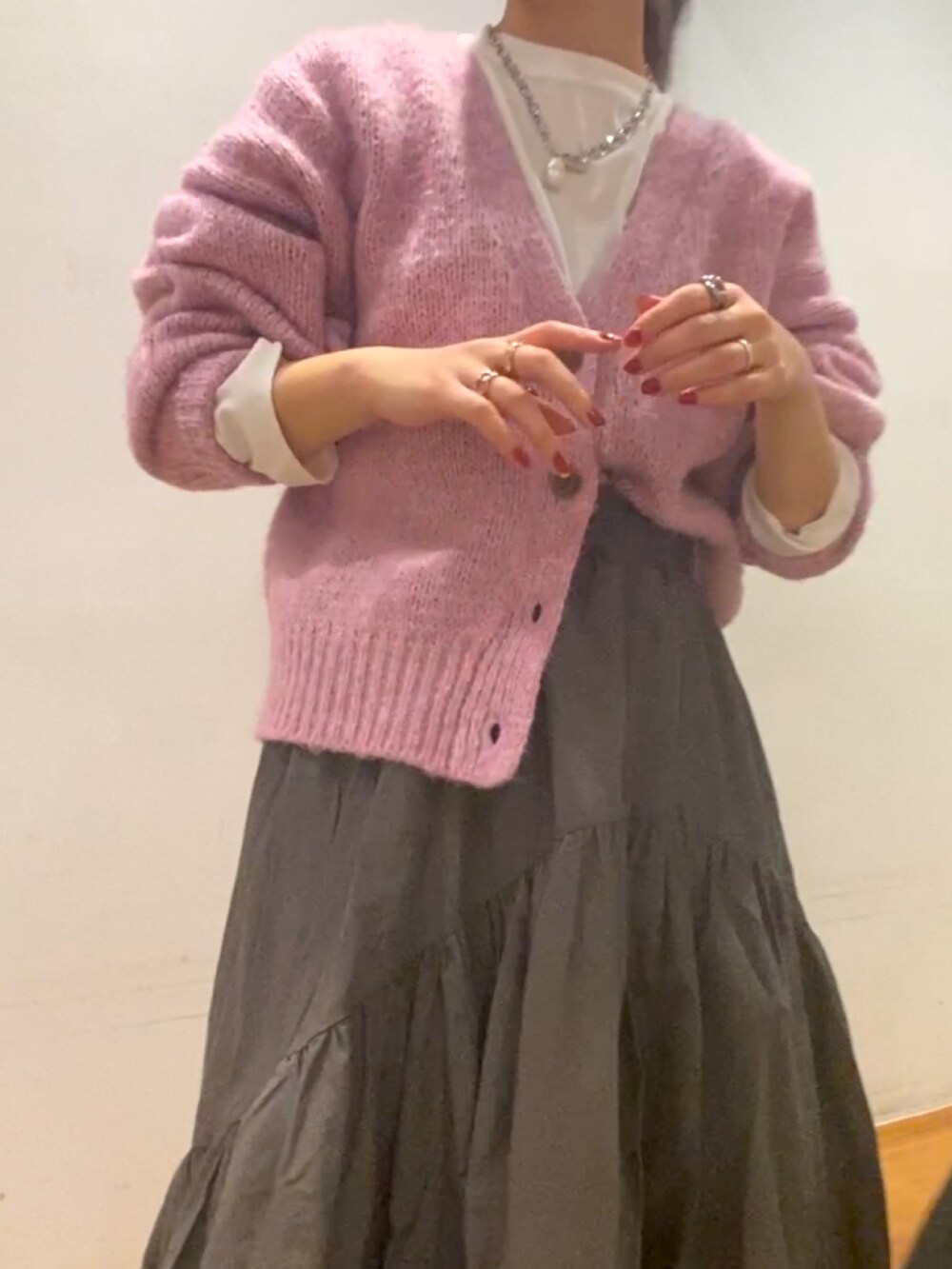 ピンク系のカーディガン/ボレロ、グレー系のスカート、ホワイト系のTシャツ/カットソーを着用したレディースの秋コーディネートの3枚目の写真