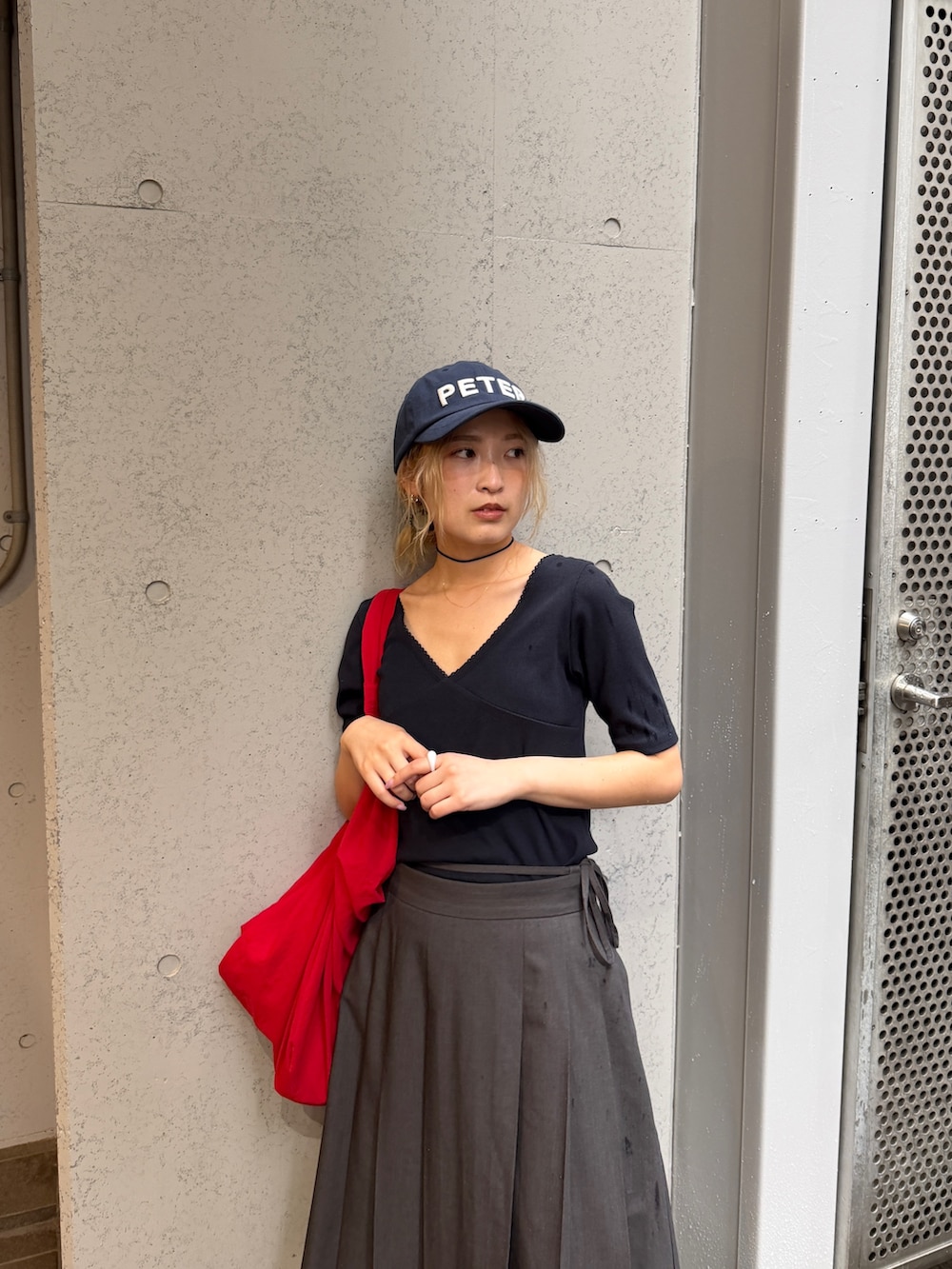 ブラック系のTシャツ/カットソー、レッド系のキャップを着用したレディースの夏コーディネートの5枚目の写真