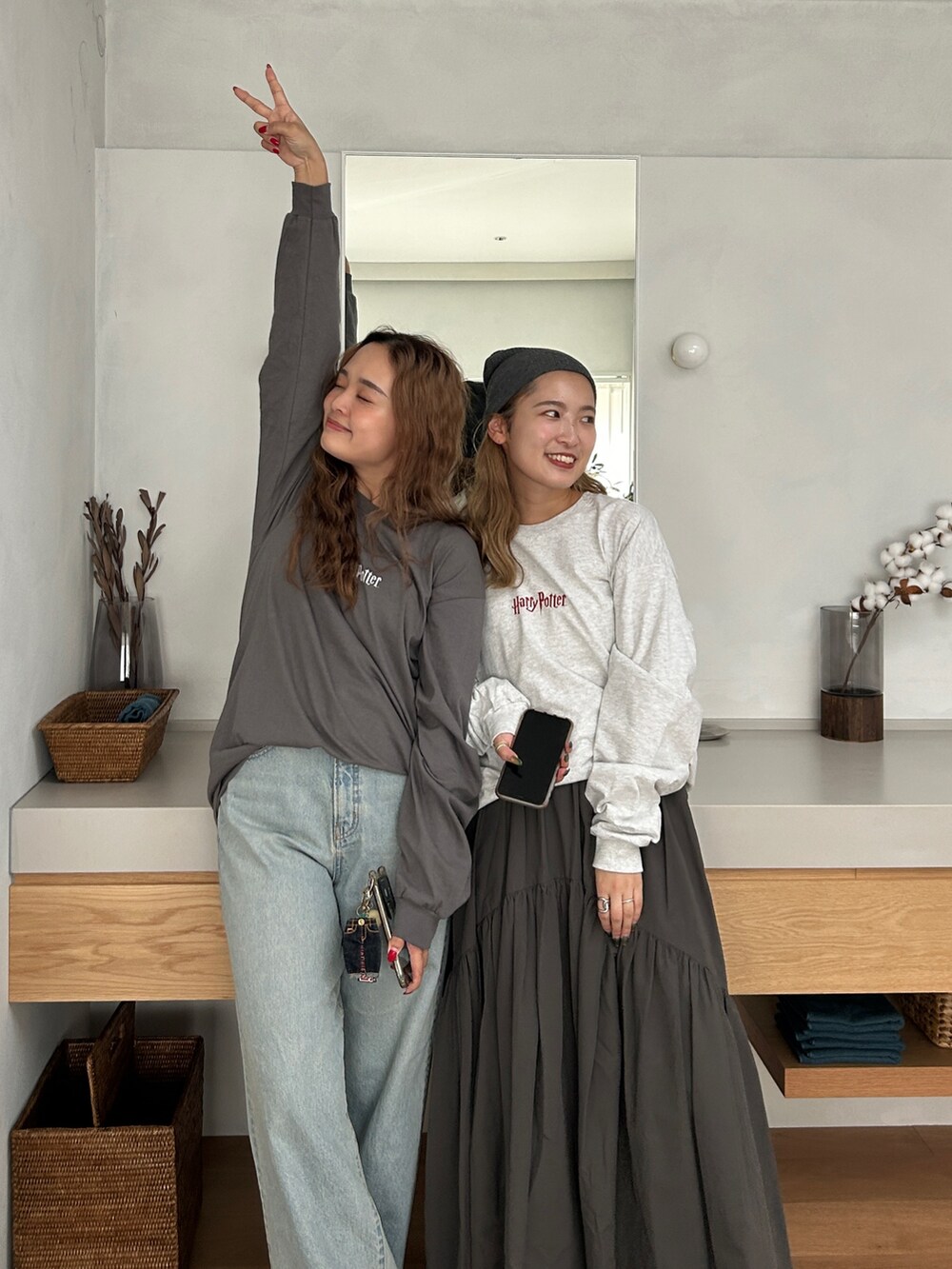 グレー系のTシャツ/カットソー、グレー系のスカート、ブルー系のデニムパンツを着用したレディースの秋コーディネートの4枚目の写真