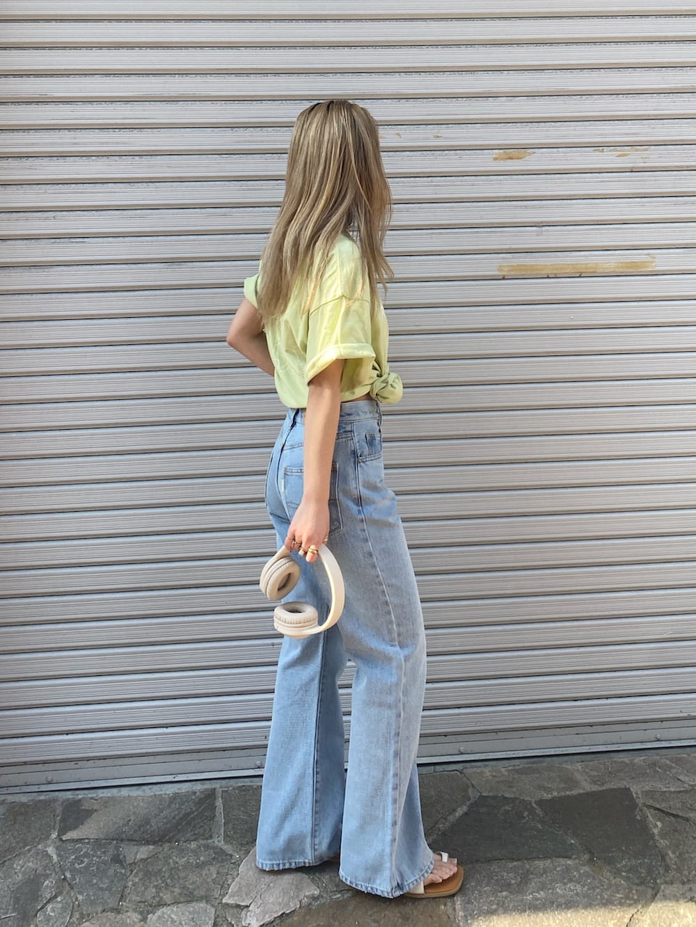 ブルー系のデニムパンツ、グリーン系のTシャツ/カットソー、ホワイト系のサンダルを着用したレディースの春コーディネートの2枚目の写真