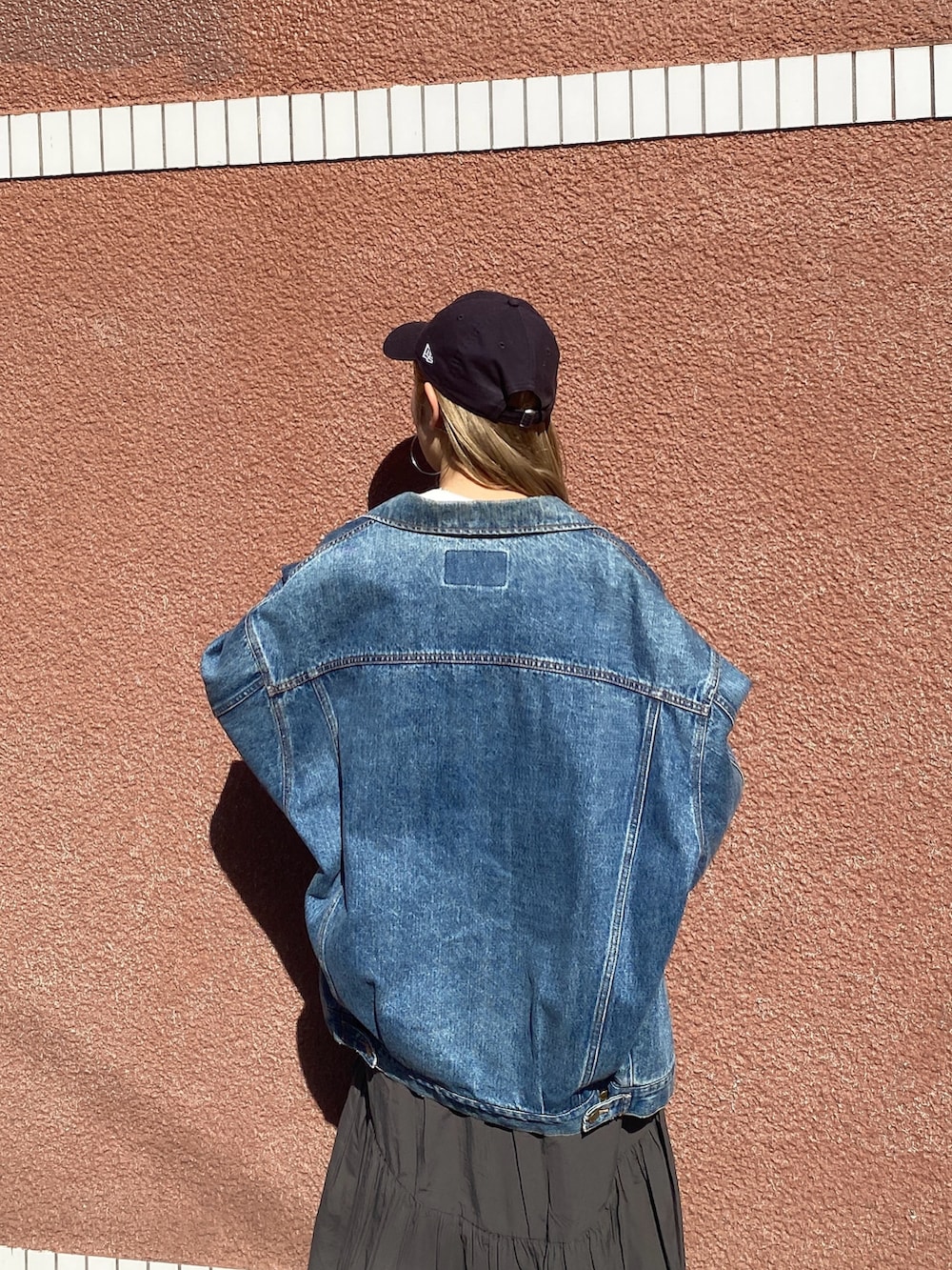 ホワイト系のTシャツ/カットソー、ブルー系のデニムジャケット、グレー系のスカートを着用したレディースの春コーディネートの2枚目の写真