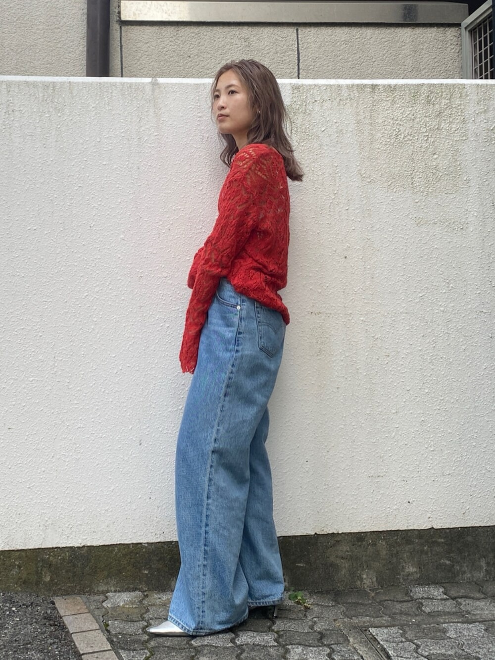 ブルー系のデニムパンツ、シルバー系のその他シューズ、オレンジ系のニット/セーターを着用したレディースの夏コーディネートの2枚目の写真