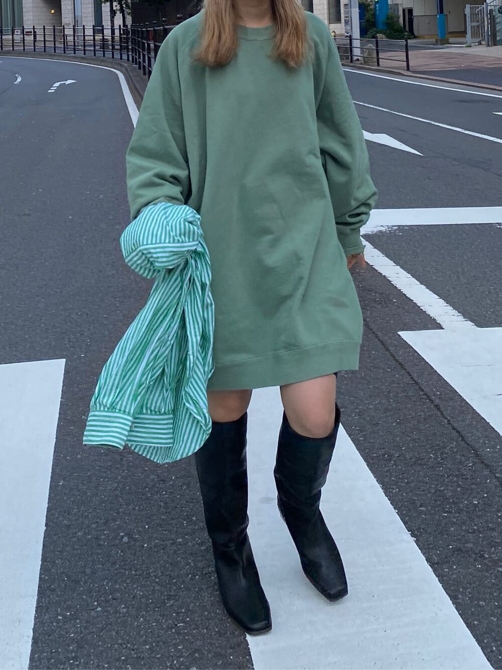 グリーン系のワンピース、グリーン系のシャツ/ブラウス、ブラック系のブーツを着用したレディースの秋コーディネートの5枚目の写真