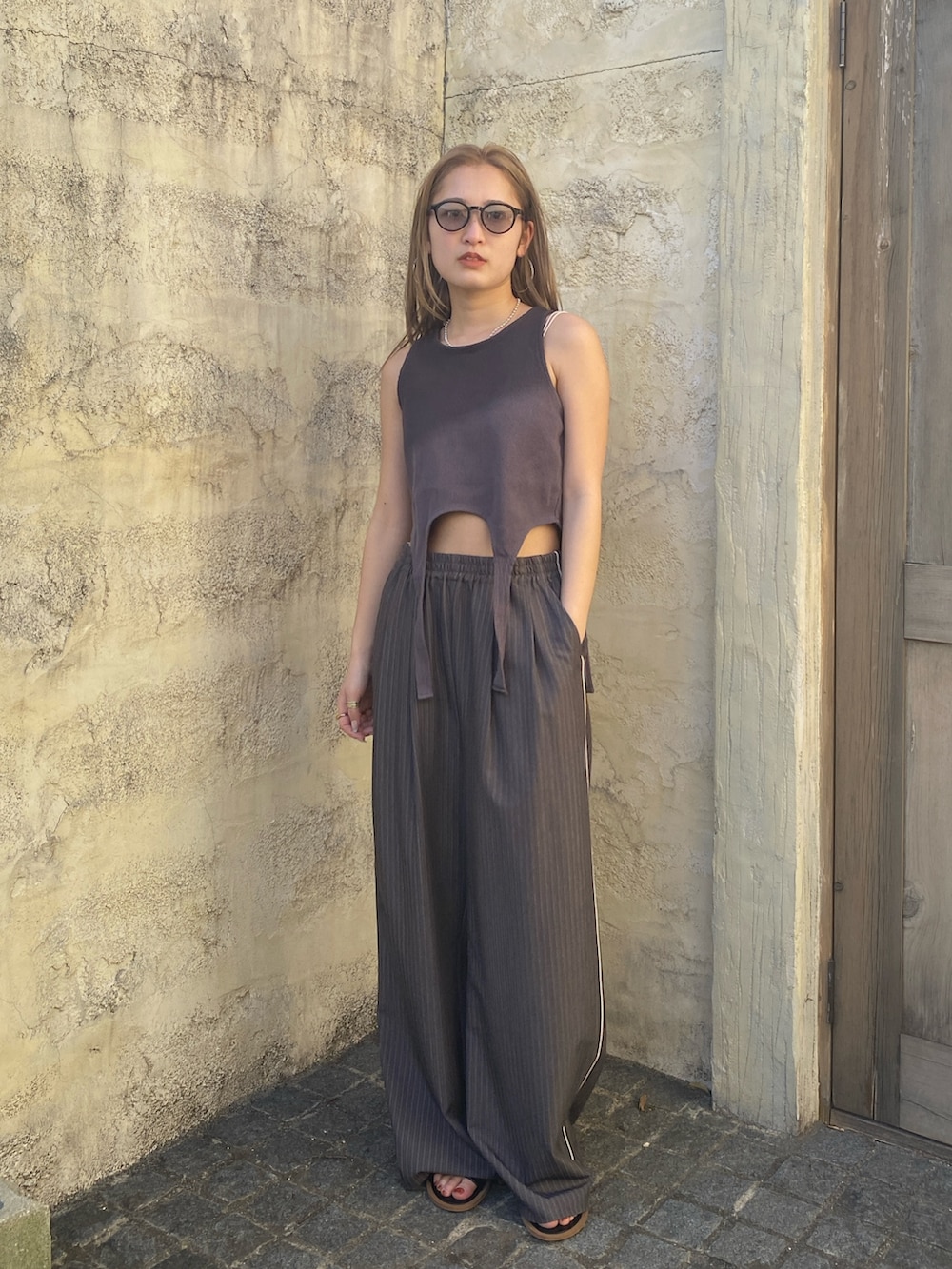 グレー系のタンクトップ、ホワイト系のキャミソール、グレー系のその他パンツを着用したレディースの春コーディネートの2枚目の写真