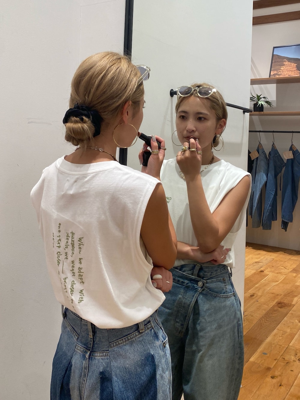 ホワイト系のタンクトップ、ブルー系のデニムパンツを着用したレディースの夏コーディネートの2枚目の写真