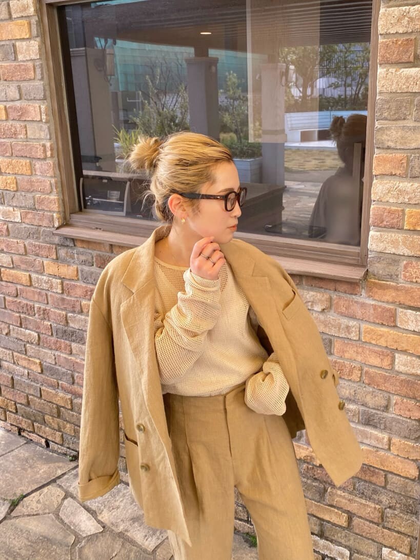 ホワイト系のタンクトップ、ベージュ系のテーラードジャケット、ベージュ系のその他パンツを着用したレディースの春コーディネートの4枚目の写真