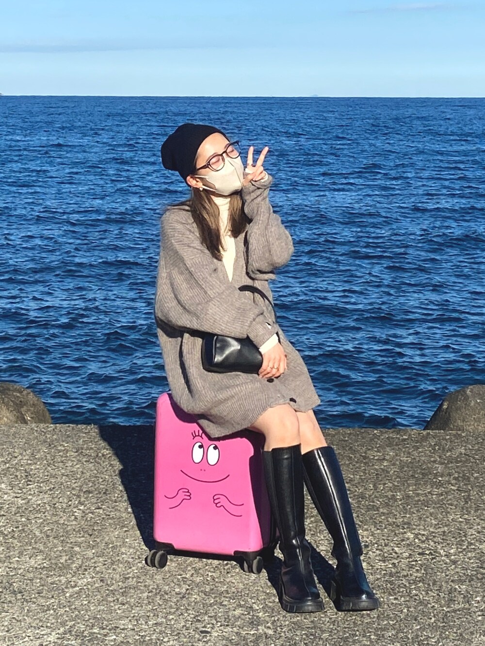 グレー系のカーディガン/ボレロ、ホワイト系のTシャツ/カットソー、ブラック系のニットキャップ/ビーニーを着用したレディースの冬コーディネートの9枚目の写真