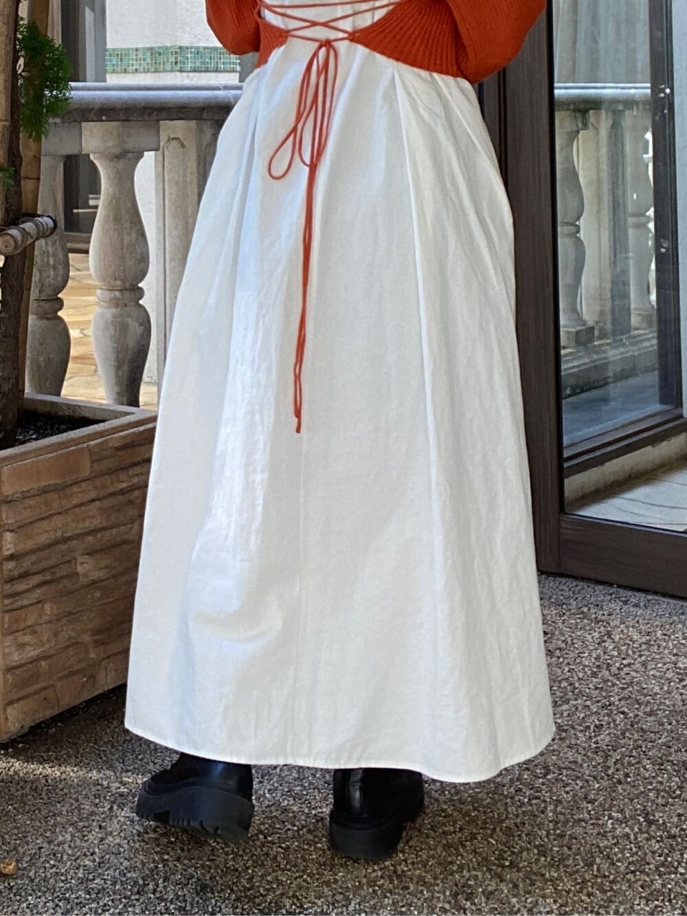 オレンジ系のワンピースを着用したレディースの秋コーディネートの6枚目の写真