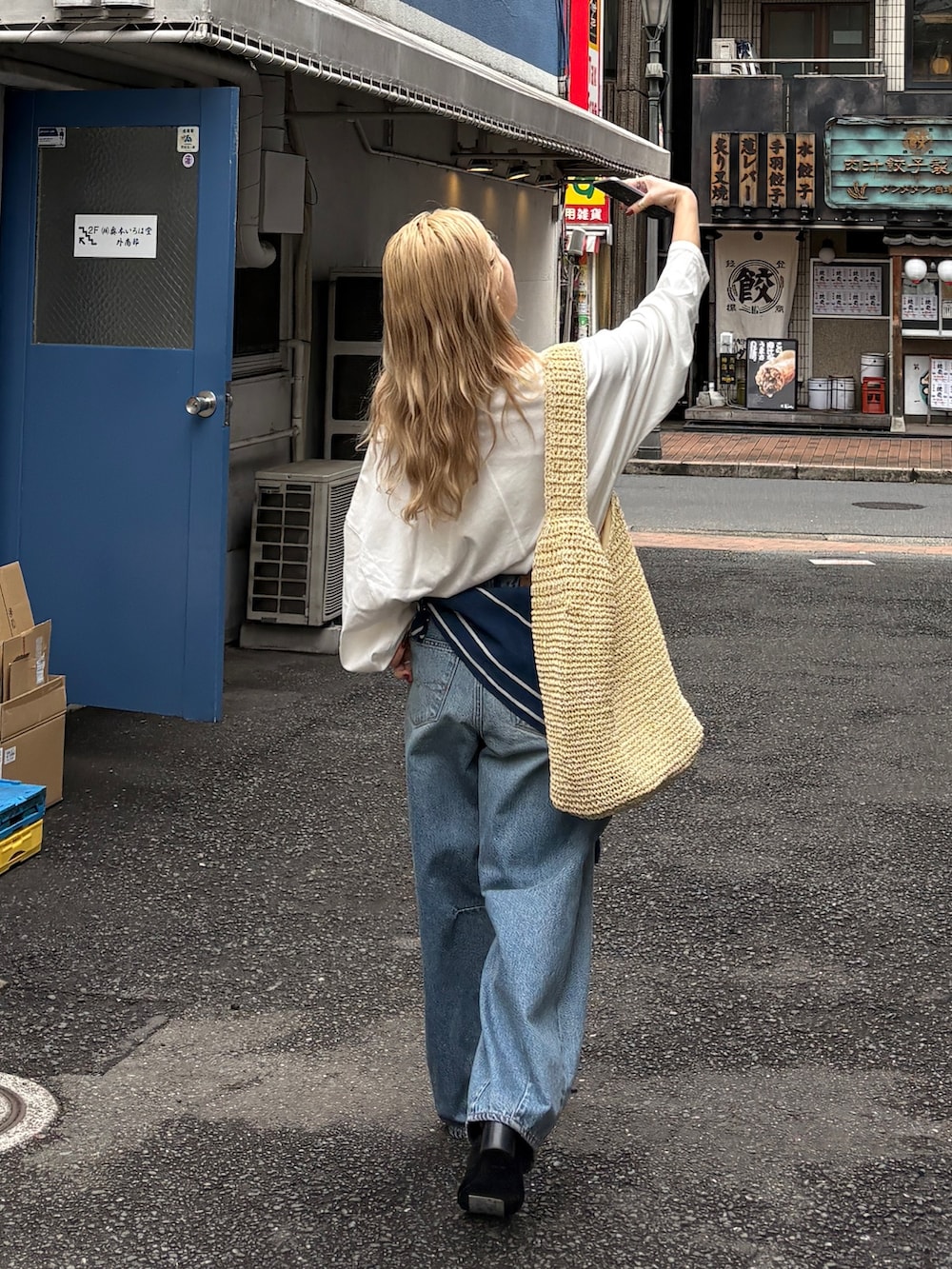 ホワイト系のTシャツ/カットソー、ブルー系のデニムパンツ、ベージュ系のショルダーバッグを着用したレディースの春コーディネートの7枚目の写真