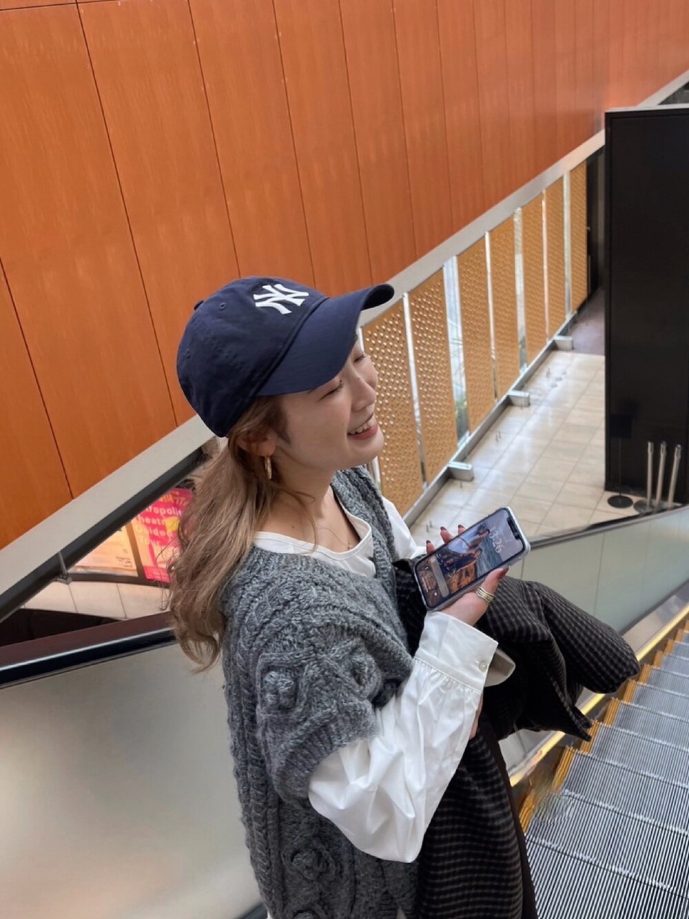 グレー系のニット/セーター、ブラック系のブーツ、ブラック系のワンピースを着用したレディースの冬コーディネートの2枚目の写真