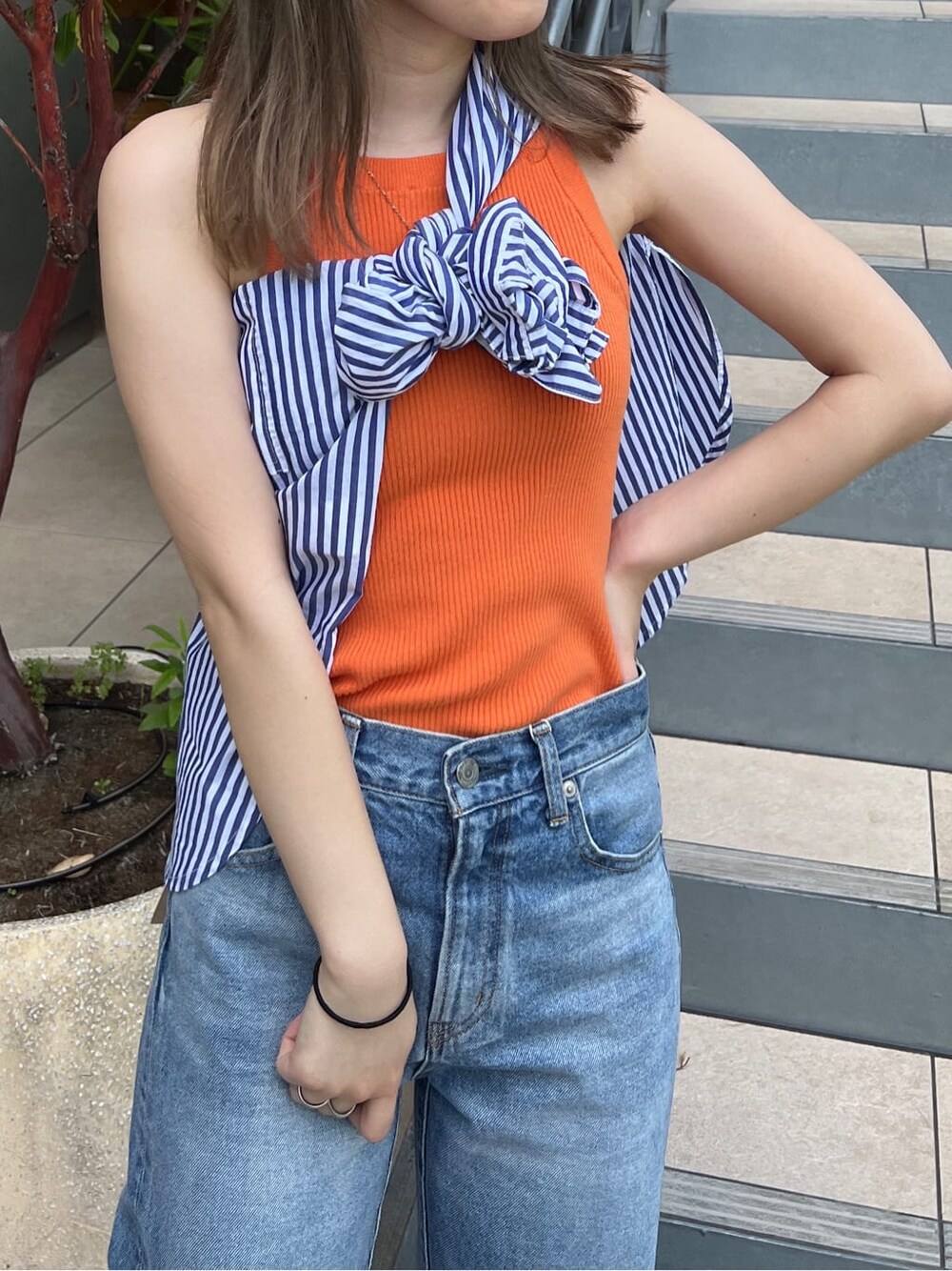 ブルー系のデニムパンツ、オレンジ系のタンクトップ、ブルー系のシャツ/ブラウスを着用したレディースの春コーディネートの3枚目の写真