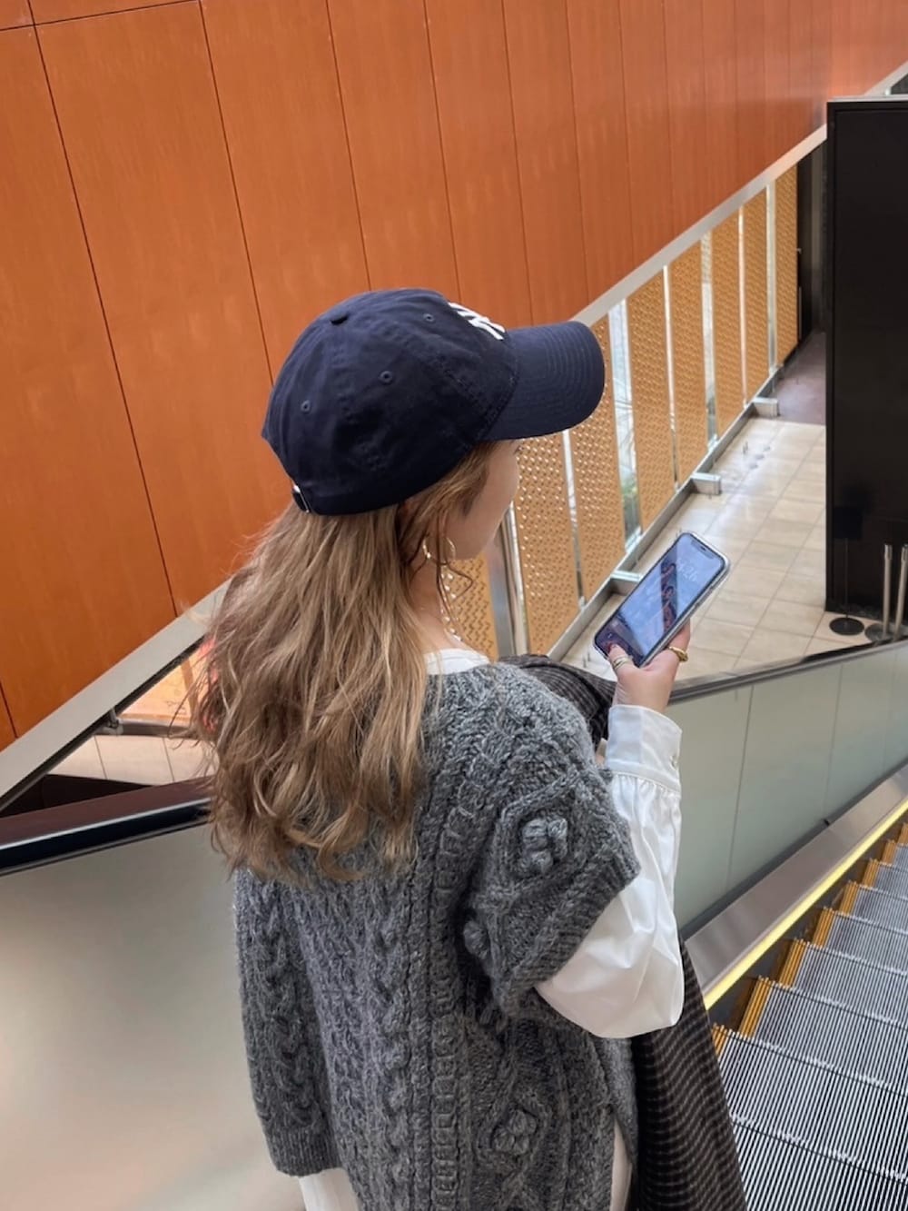 グレー系のニット/セーター、ブラック系のブーツ、ブラック系のワンピースを着用したレディースの冬コーディネートの3枚目の写真