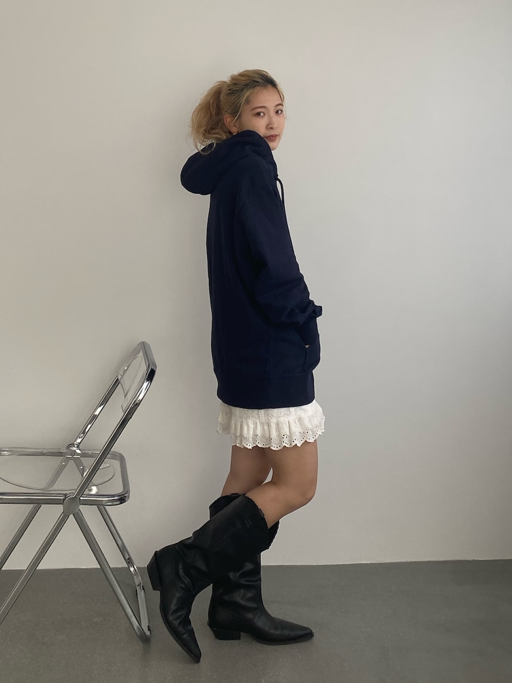 ブルー系のパーカー、ホワイト系のその他パンツ、ブラック系のブーツを着用したレディースの春コーディネートの2枚目の写真