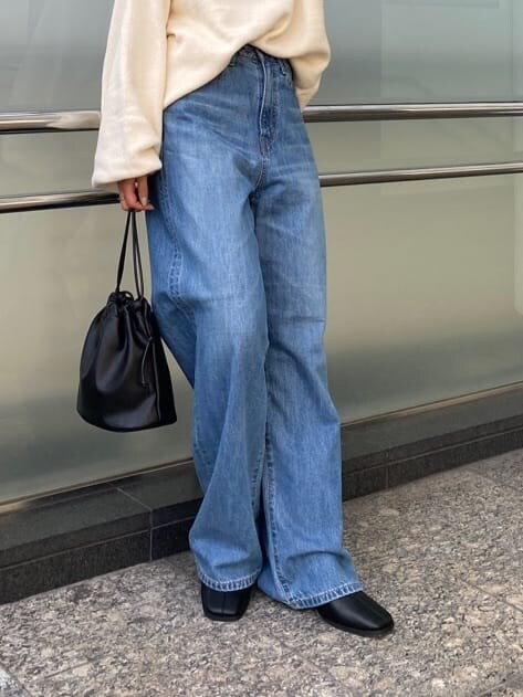 ブルー系のデニムパンツ、ブラック系のブーツ、ブラック系のハンドバッグを着用したレディースの秋コーディネートの9枚目の写真