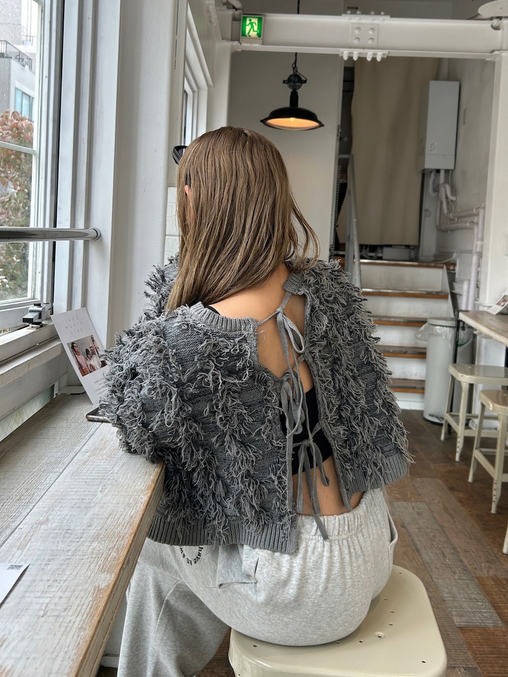 グレー系のニット/セーター、グレー系のスウェットパンツ、ブラック系のヘアバンドを着用したレディースの秋コーディネートの2枚目の写真