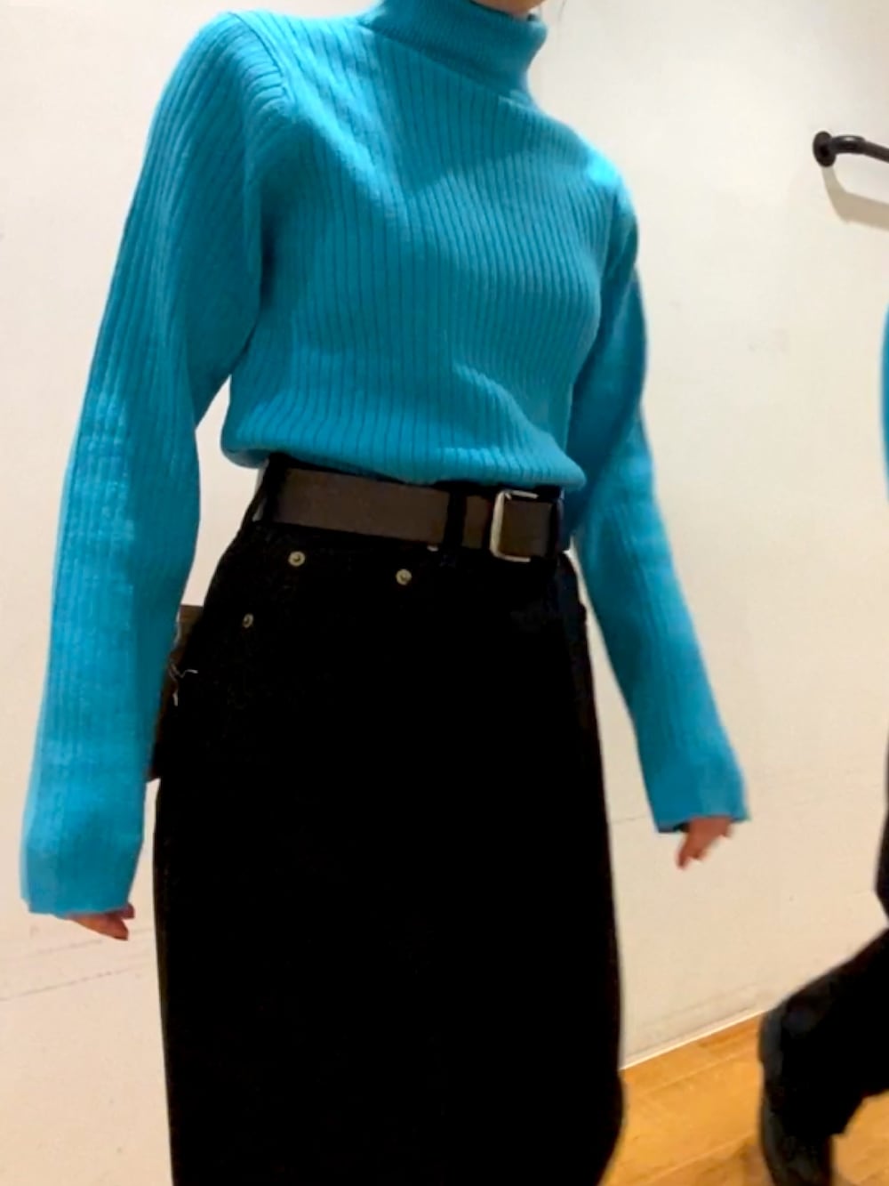 ブラック系のデニムパンツ、ブラック系のブーツ、ブルー系のニット/セーターを着用したレディースの秋コーディネートの3枚目の写真