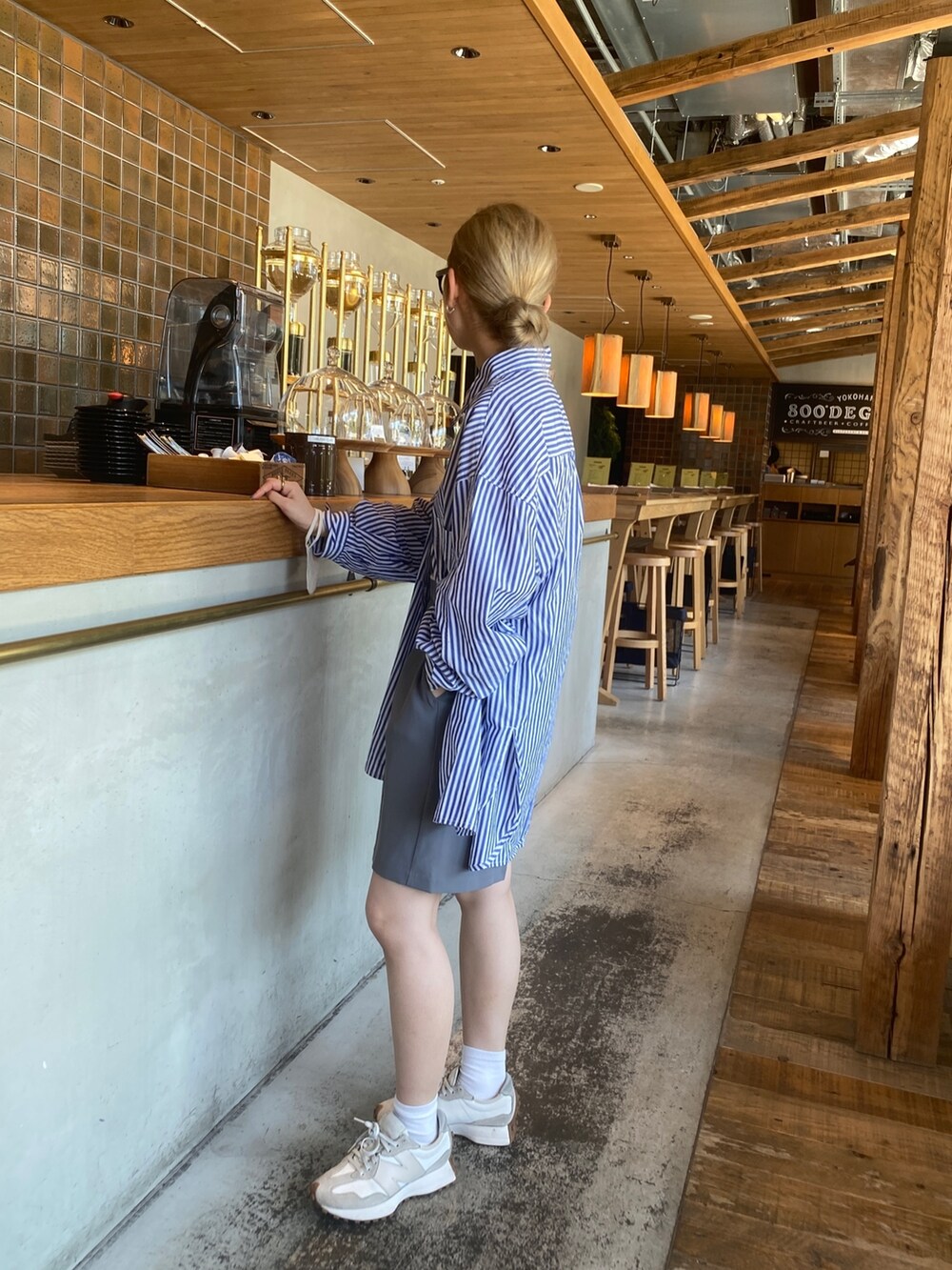 ブルー系のシャツ/ブラウス、グレー系のパンツ、ブラック系のサングラスを着用したレディースの夏コーディネートの3枚目の写真