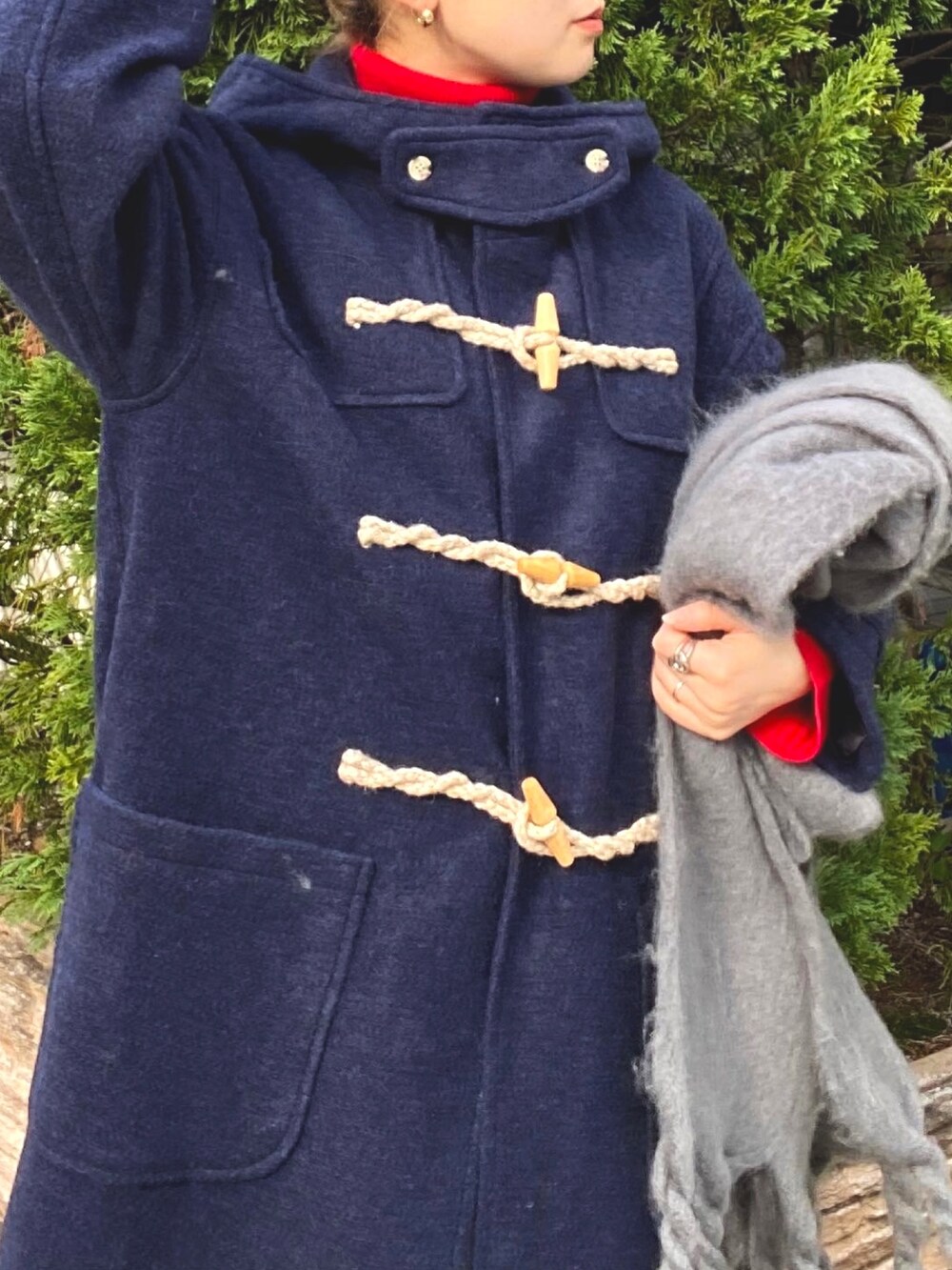 ホワイト系のスカート、ブルー系のダッフルコート、レッド系のニット/セーターを着用したレディースの冬コーディネートの6枚目の写真