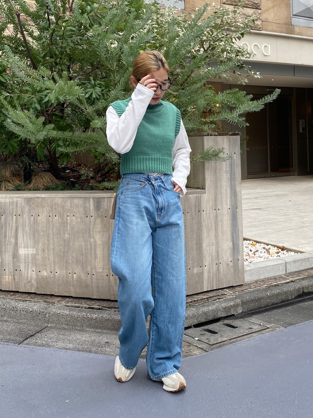 ブルー系のデニムパンツ、グリーン系のワンピースを着用したレディースの冬コーディネートの4枚目の写真