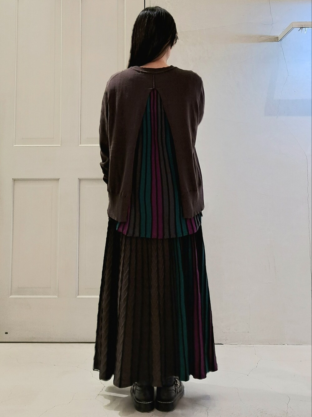 ブラック系のニット/セーター、ブラック系のスカート、ブラック系のその他シューズを着用したレディースの冬コーディネートの3枚目の写真