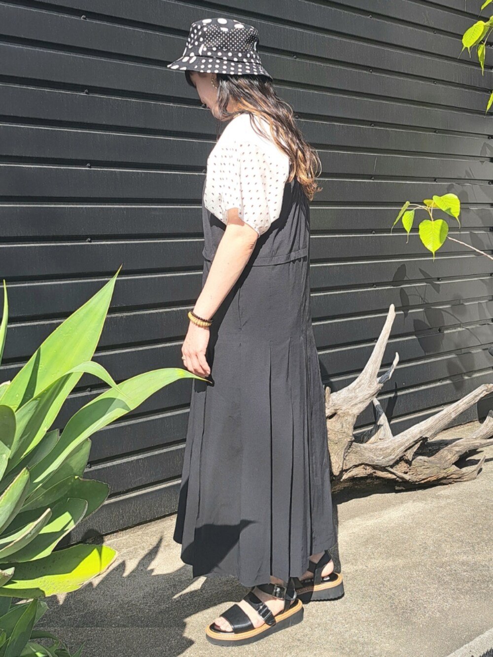 ホワイト系のTシャツ/カットソー、ブラック系のワンピース、ブラック系のサンダルを着用したレディースの春コーディネートの2枚目の写真