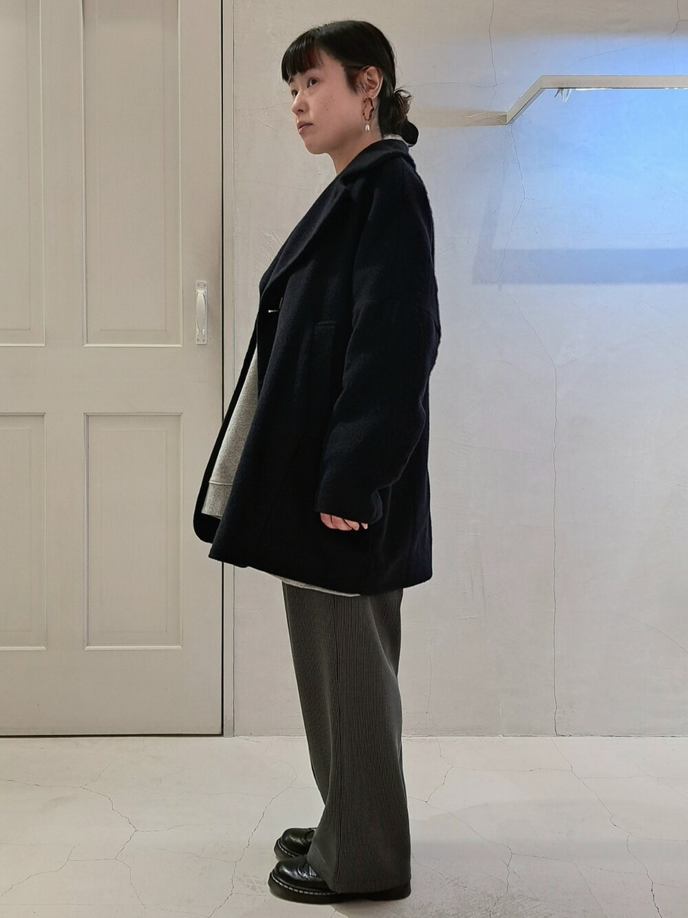 ブルー系のピーコート、グレー系のスウェット、グレー系のスラックスを着用したレディースの秋コーディネートの2枚目の写真