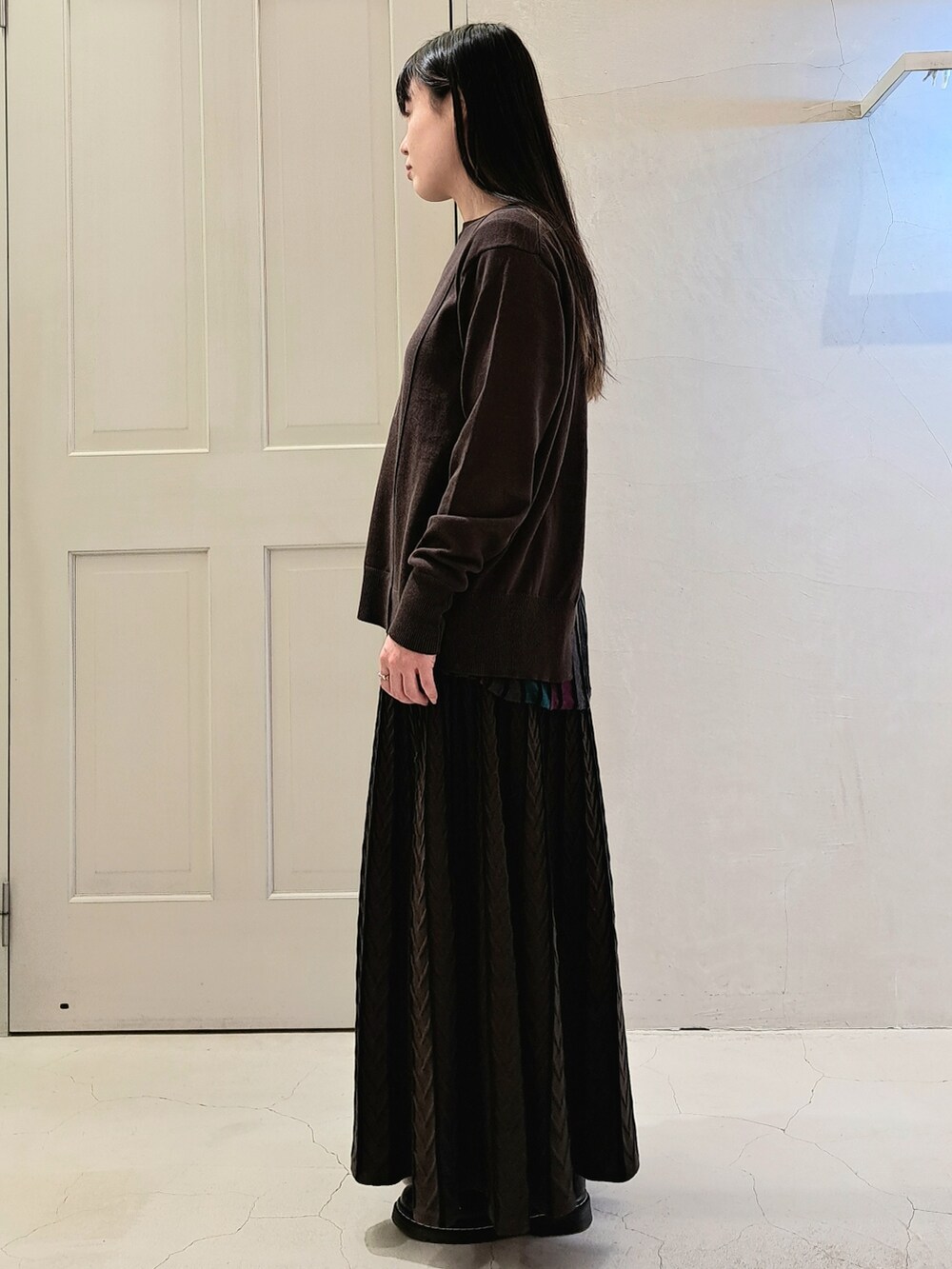 ブラック系のニット/セーター、ブラック系のスカート、ブラック系のその他シューズを着用したレディースの冬コーディネートの2枚目の写真