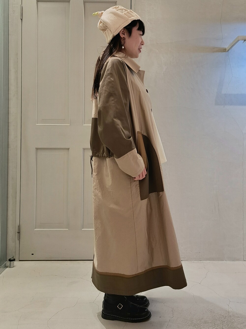 ホワイト系のTシャツ/カットソー、ベージュ系のステンカラーコート、グレー系のスカートを着用したレディースの秋コーディネートの4枚目の写真