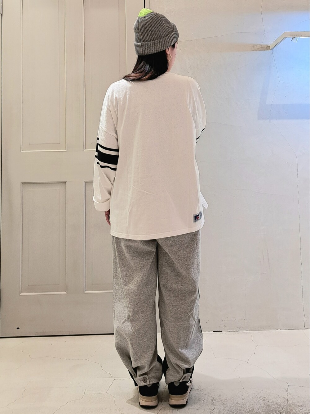 ホワイト系のTシャツ/カットソー、ブラック系のその他パンツ、グレー系のニットキャップ/ビーニーを着用したレディースの冬コーディネートの3枚目の写真