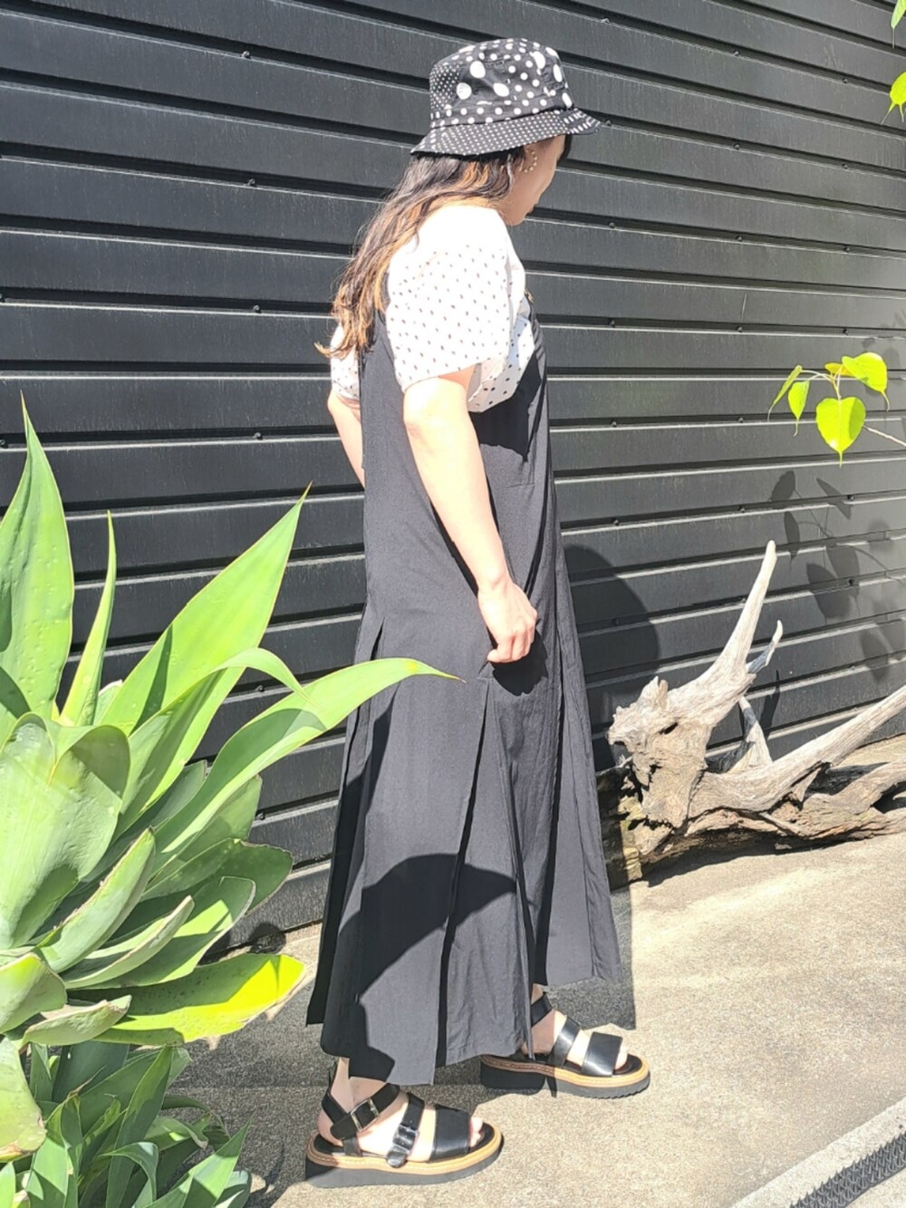 ホワイト系のTシャツ/カットソー、ブラック系のワンピース、ブラック系のサンダルを着用したレディースの春コーディネートの4枚目の写真