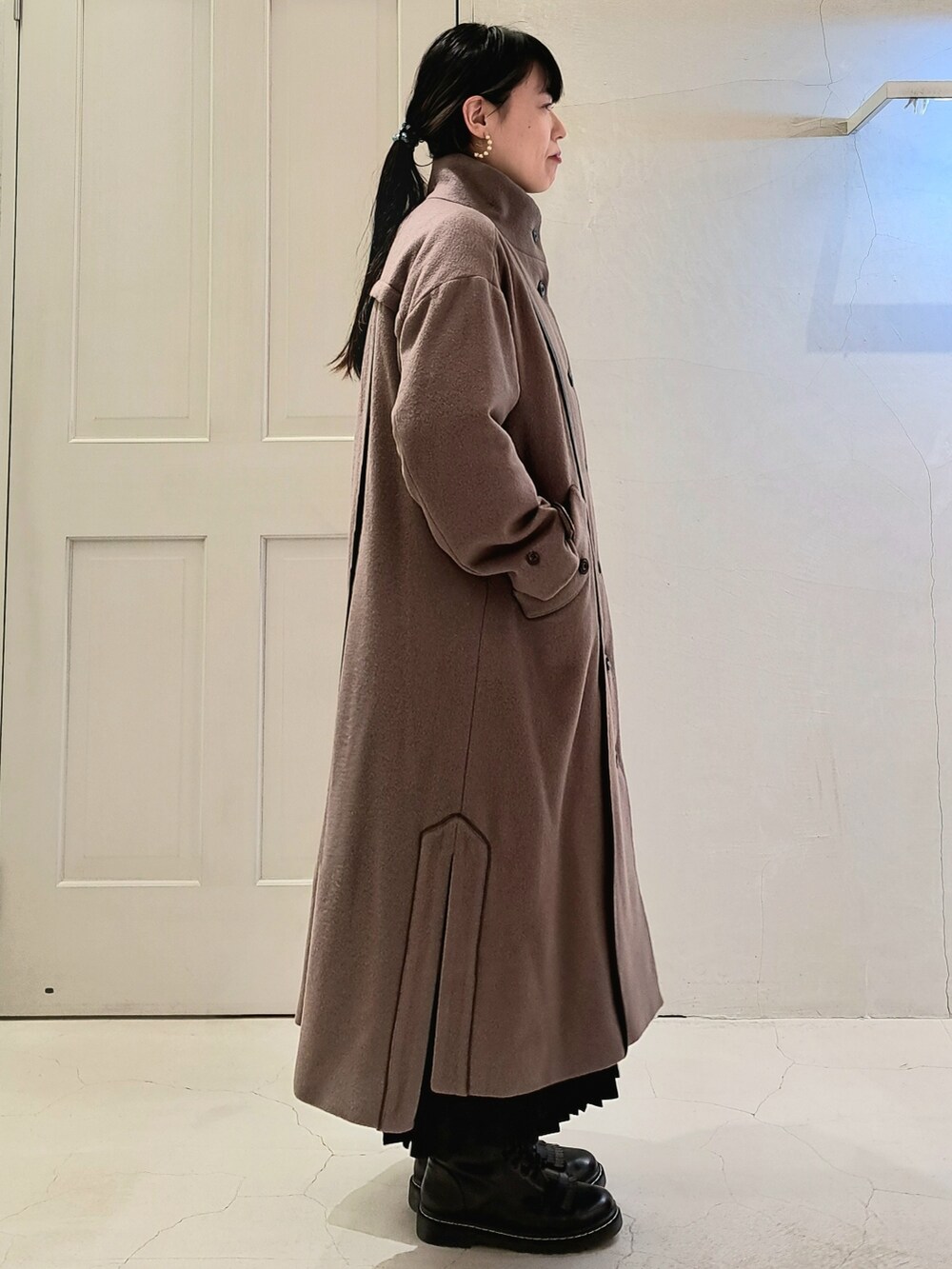 ブラウン系のその他アウター、ブラック系のスカート、ブラック系のブーツを着用したレディースの秋コーディネートの4枚目の写真