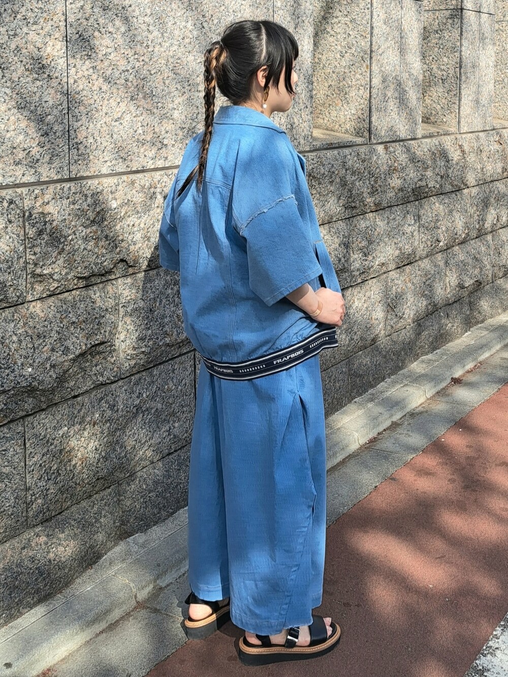 ブルー系のデニムジャケット、グレー系のニット/セーター、ブルー系のその他パンツを着用したレディースの春コーディネートの4枚目の写真