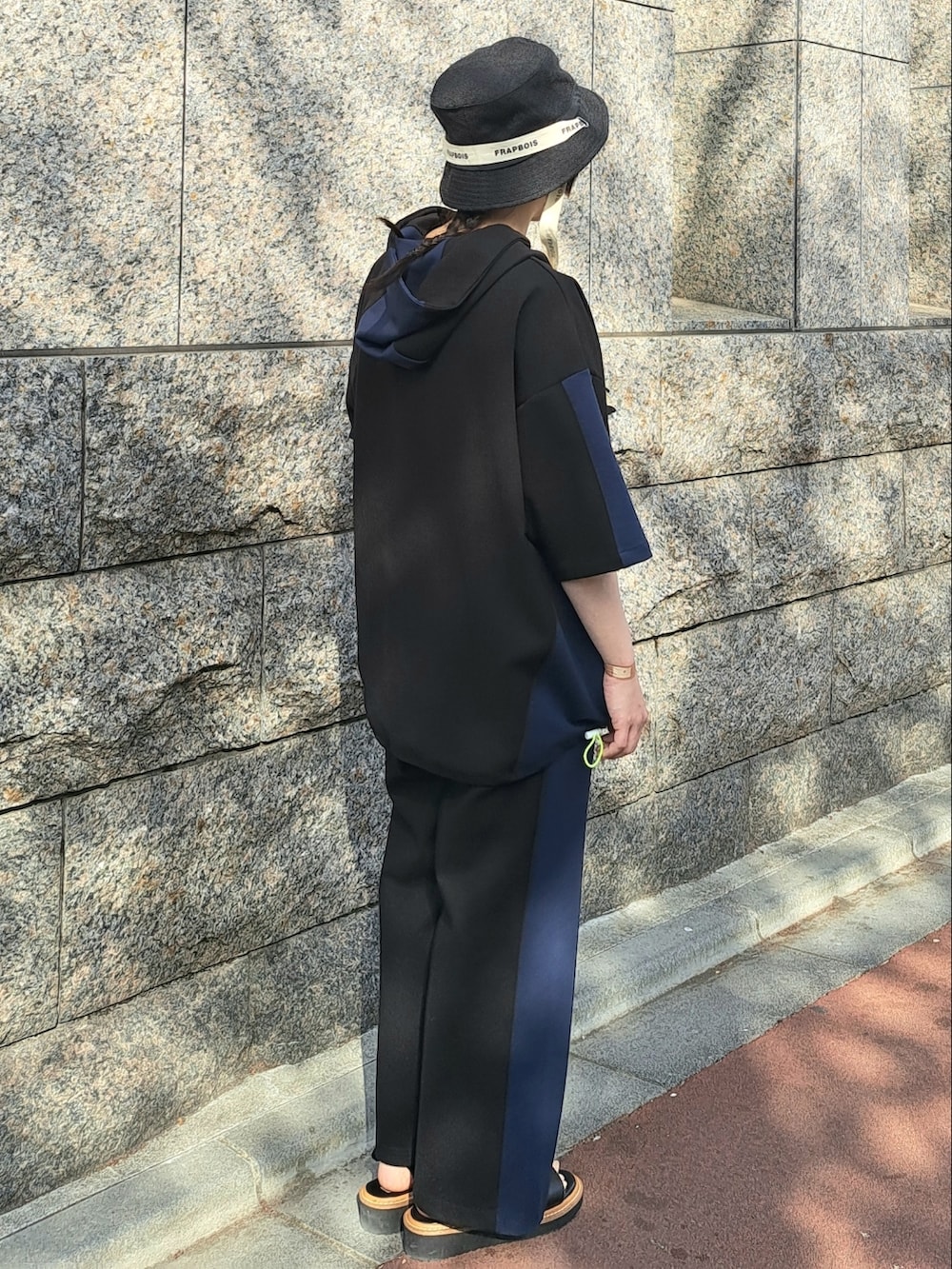 ブラック系のパーカー、ブラック系のその他パンツ、ブラック系のハットを着用したレディースの春コーディネートの4枚目の写真