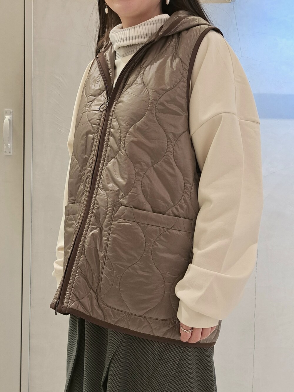 ホワイト系のTシャツ/カットソー、ベージュ系のステンカラーコート、グレー系のスカートを着用したレディースの秋コーディネートの5枚目の写真