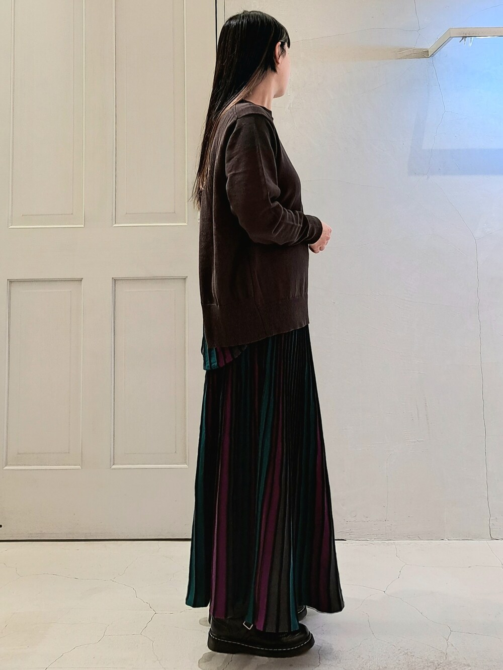 ブラック系のニット/セーター、ブラック系のスカート、ブラック系のその他シューズを着用したレディースの冬コーディネートの4枚目の写真