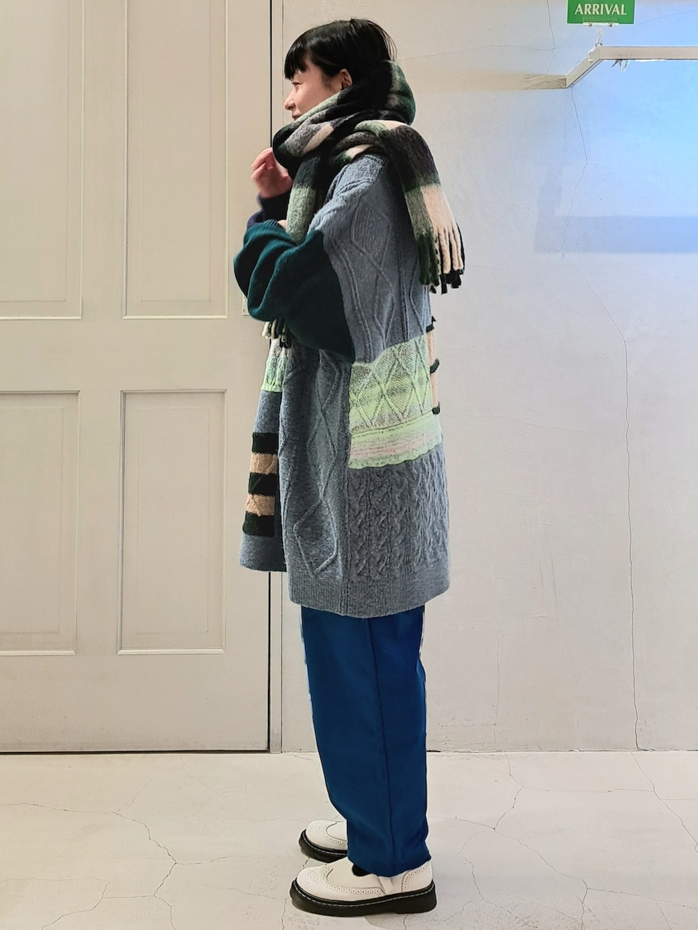 ブルー系のニット/セーター、ブルー系のその他パンツ、ホワイト系のその他シューズを着用したレディースの冬コーディネートの2枚目の写真