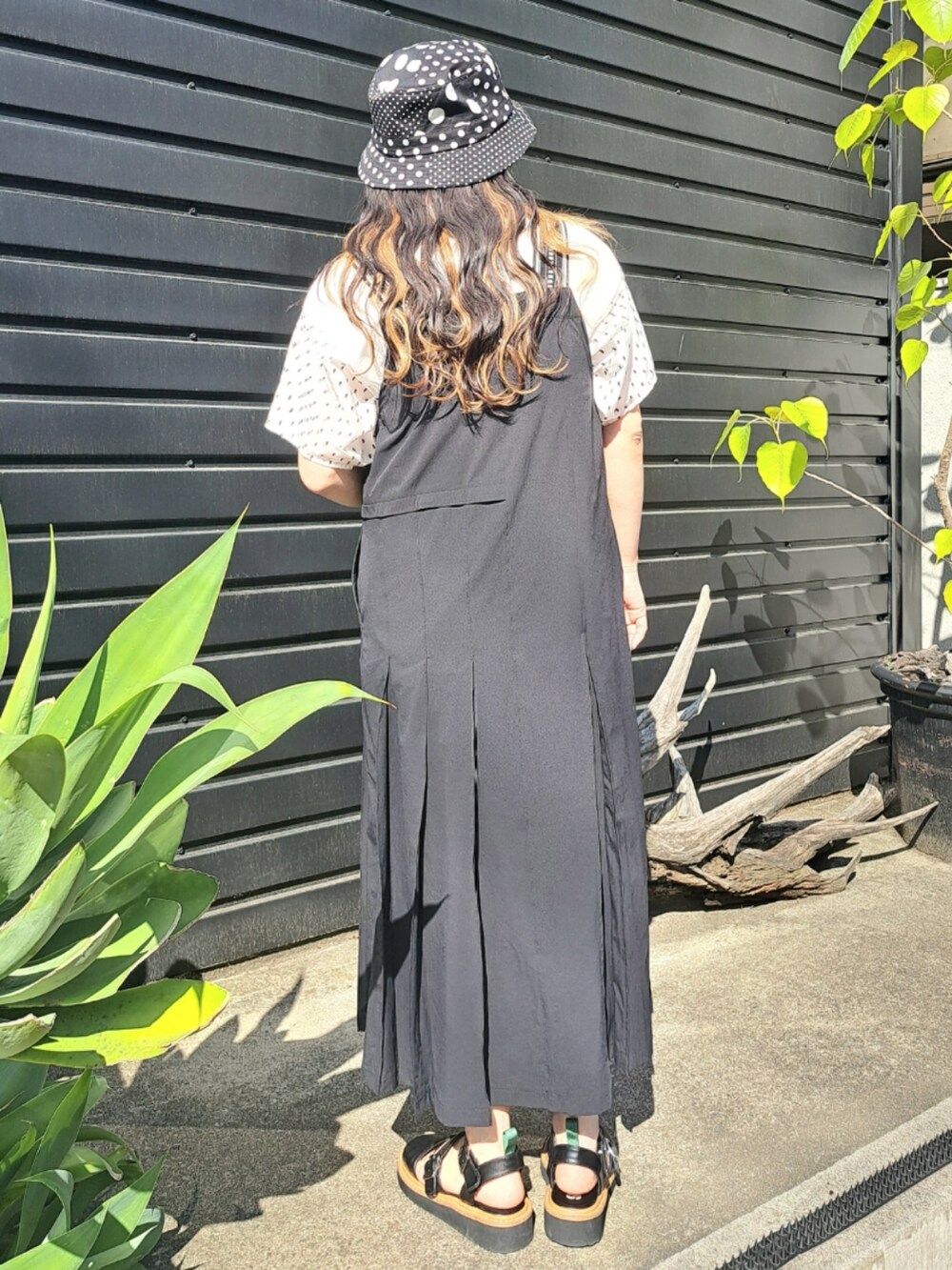 ホワイト系のTシャツ/カットソー、ブラック系のワンピース、ブラック系のサンダルを着用したレディースの春コーディネートの3枚目の写真